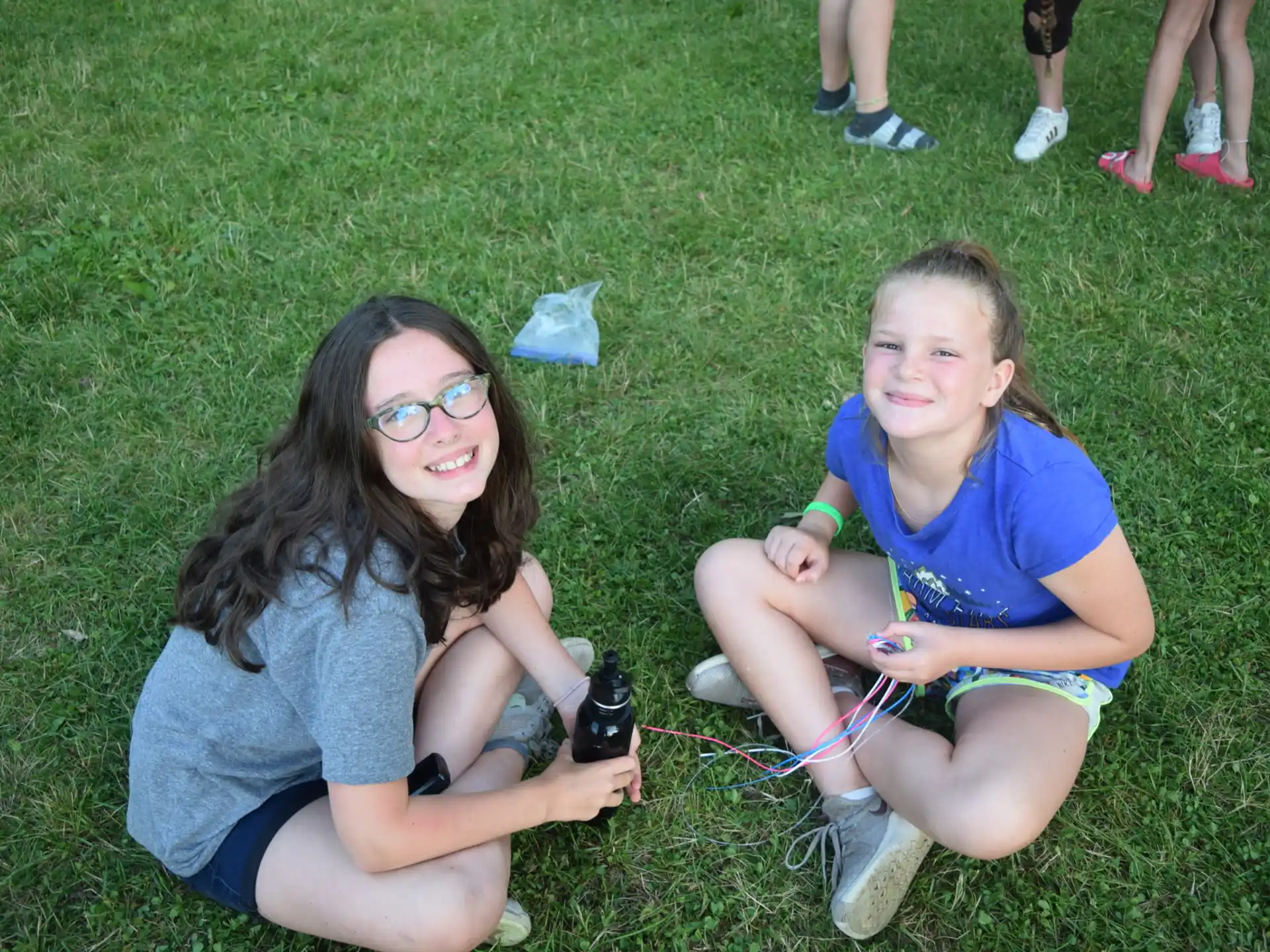 two girls sitting on the grass