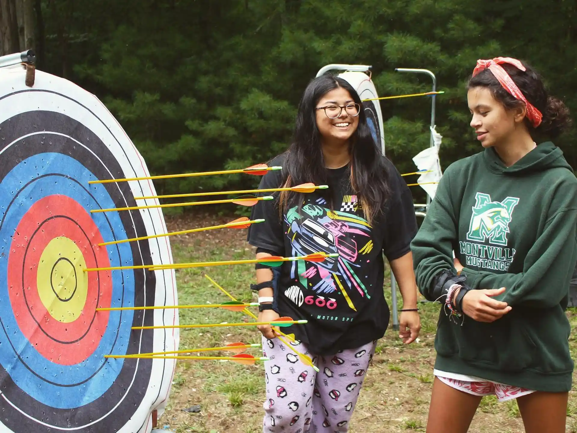 a couple of girls standing next to a kite