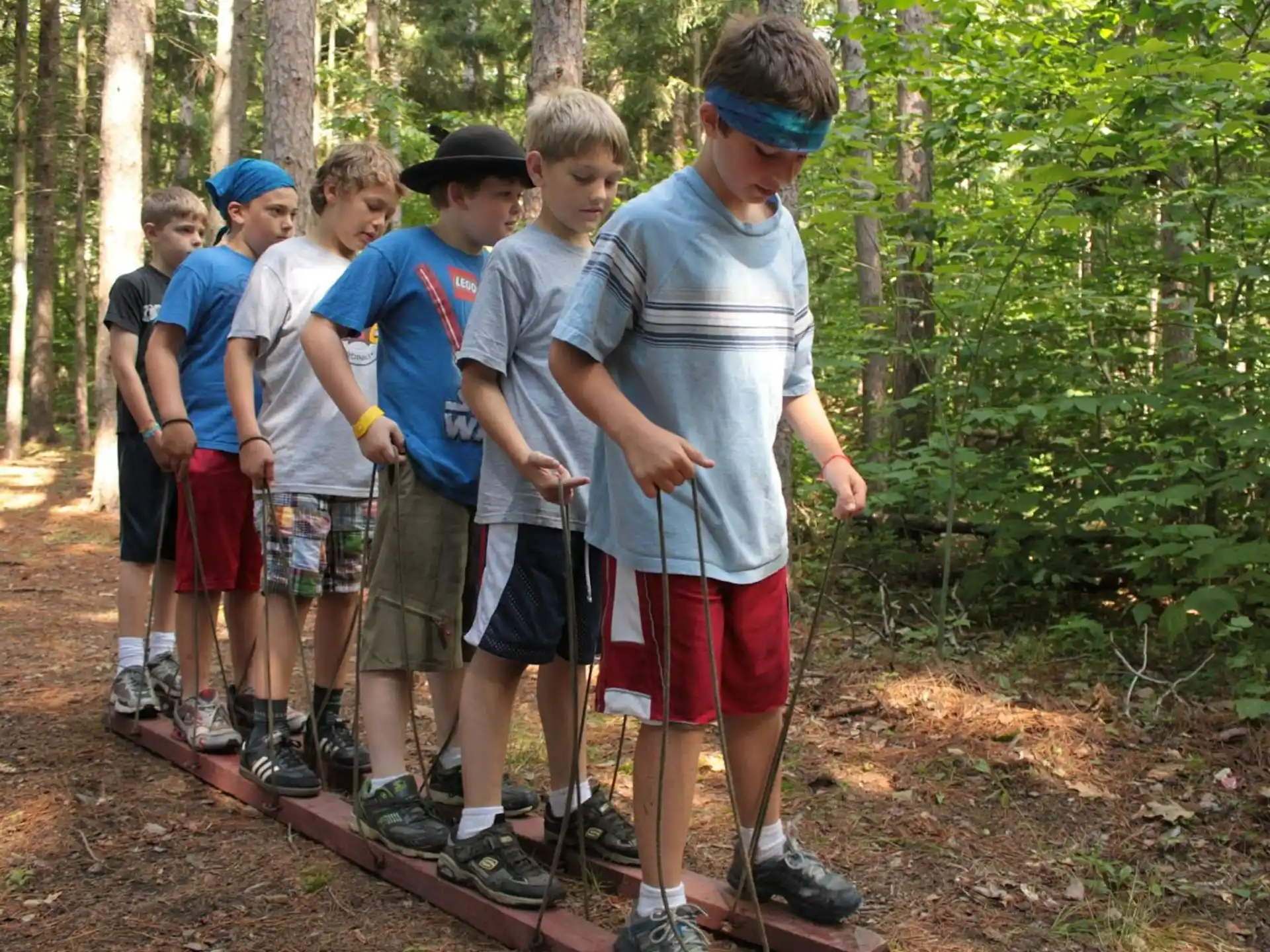 a group of boys standing in a forest