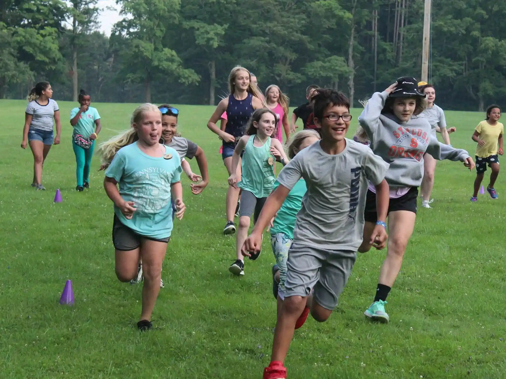 a group of people running on a grass field