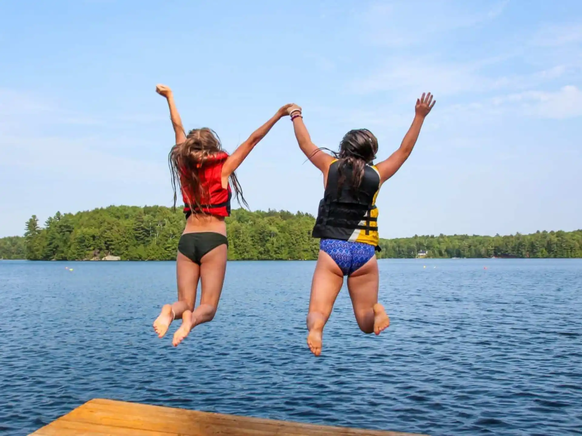 two women jumping into water