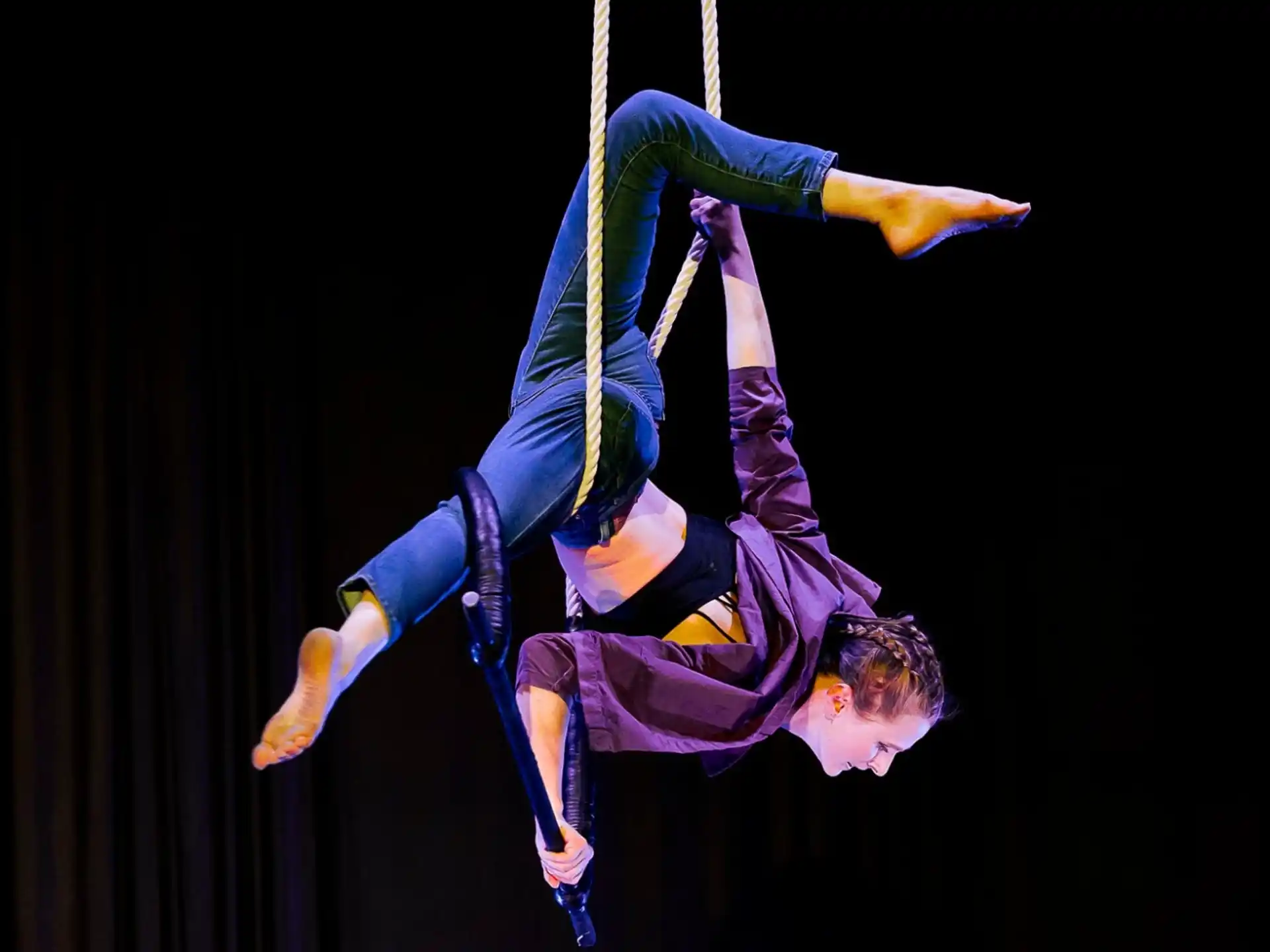 a person from a rope with Circus Juventas in the background