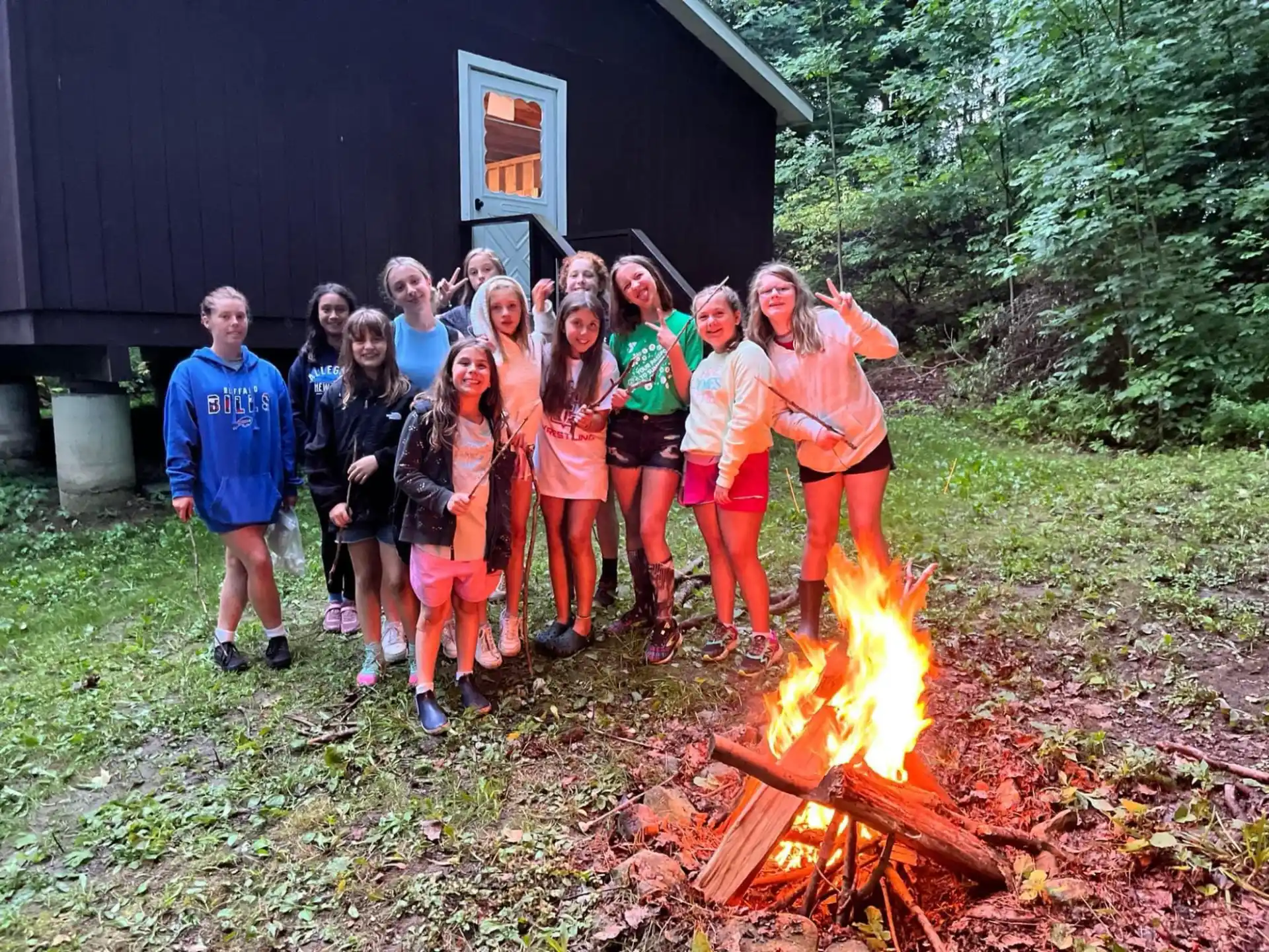 a group of people posing for a photo next to a fire