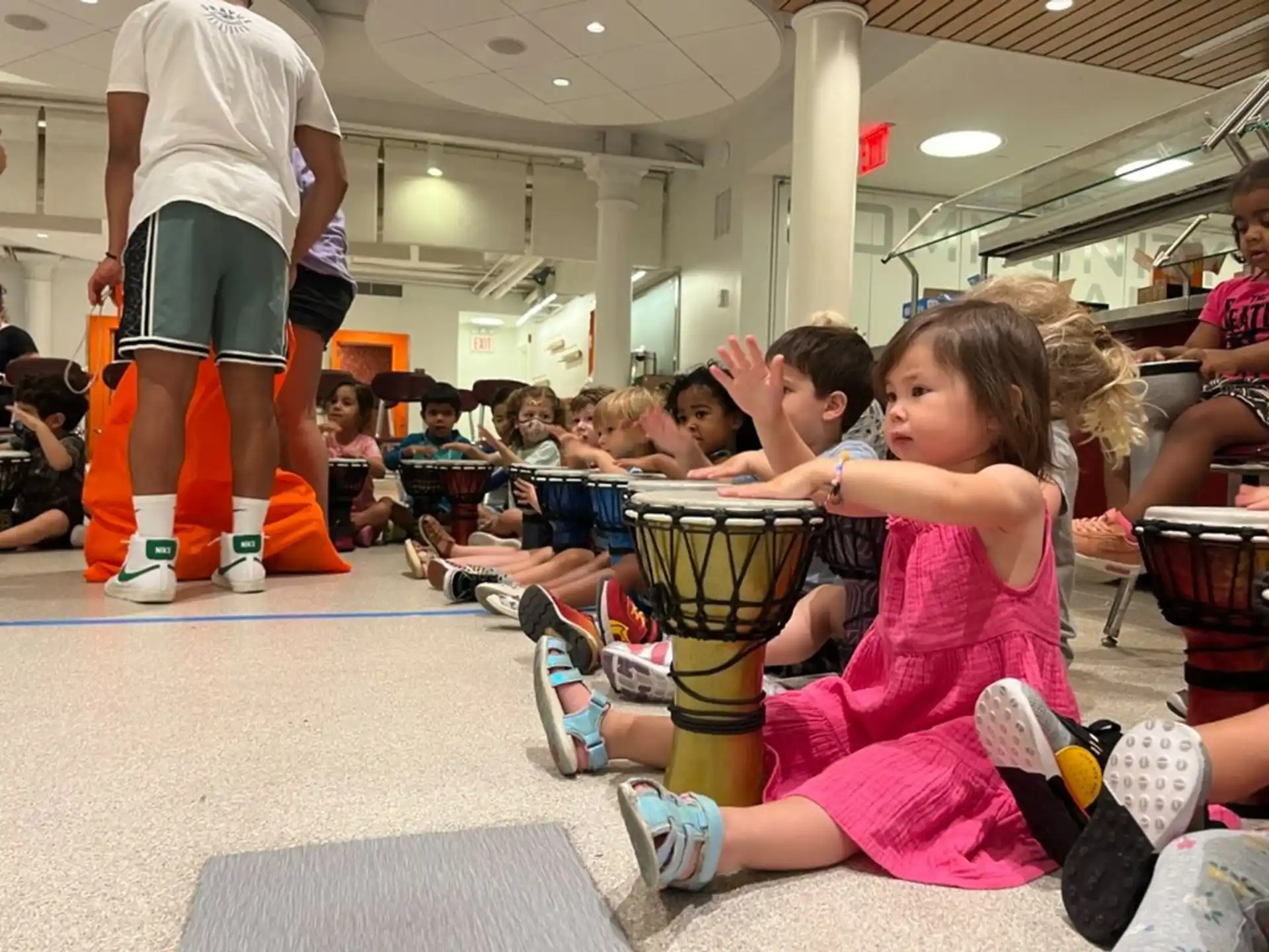 a group of children sitting on the floor in a gym