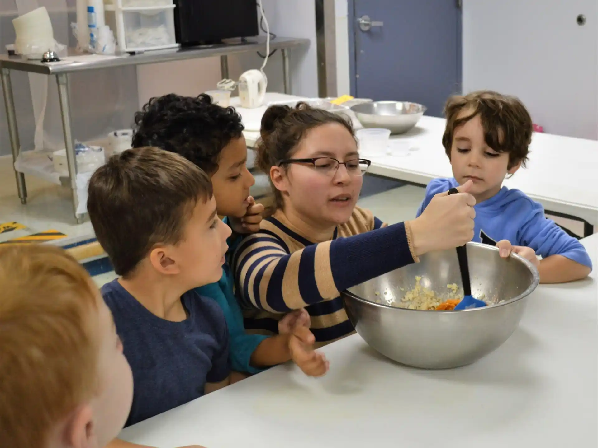 a group of boys eating from a bowl