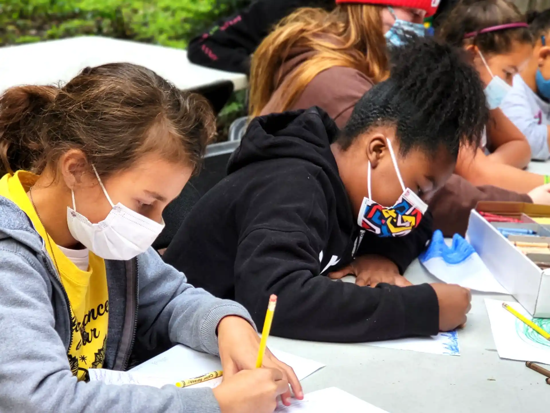 a group of children writing on paper