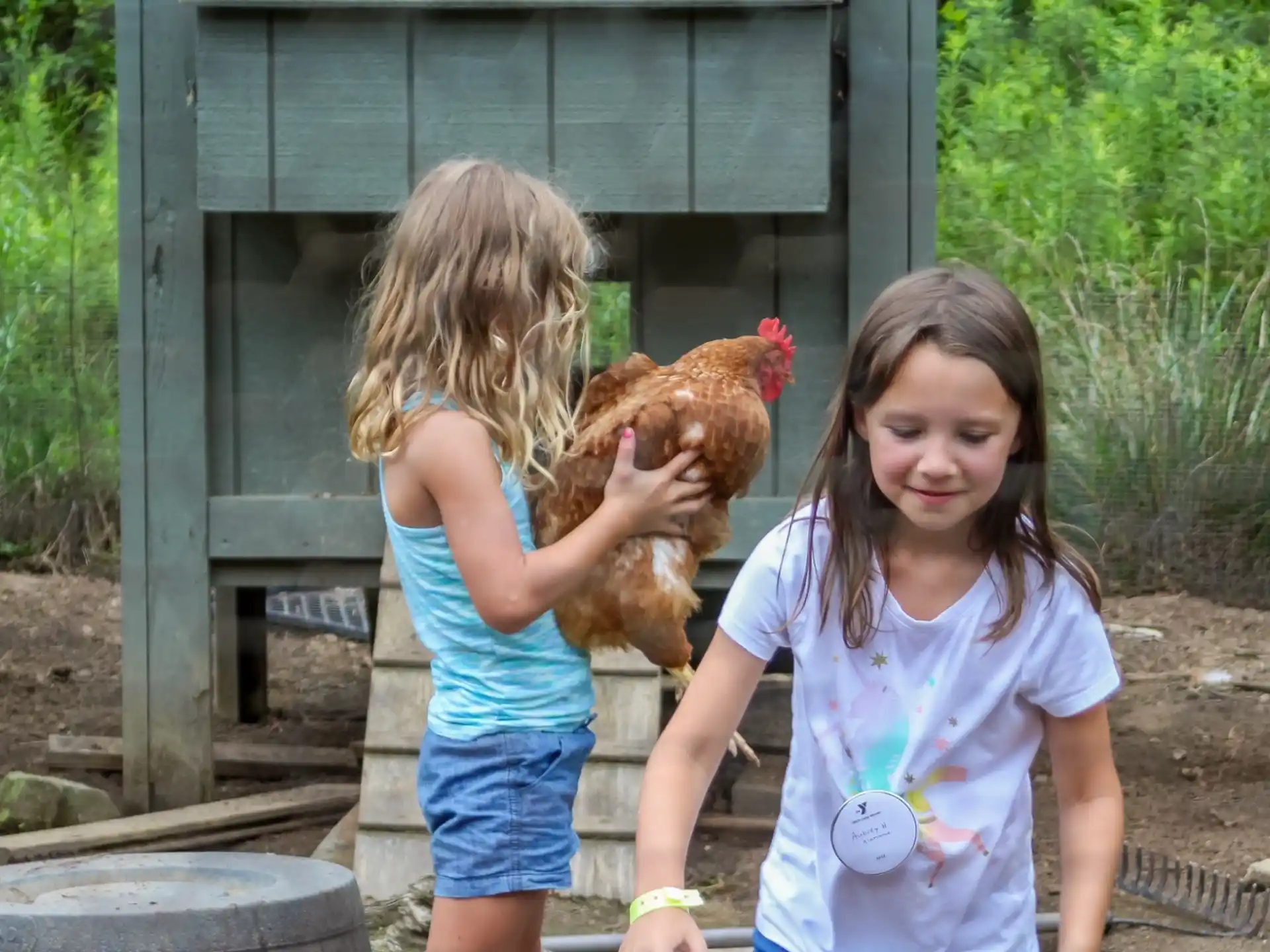 a couple of girls holding chickens