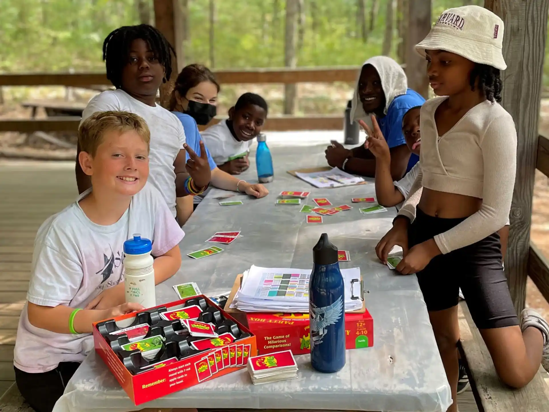 a group of children sitting at a table with food and drinks