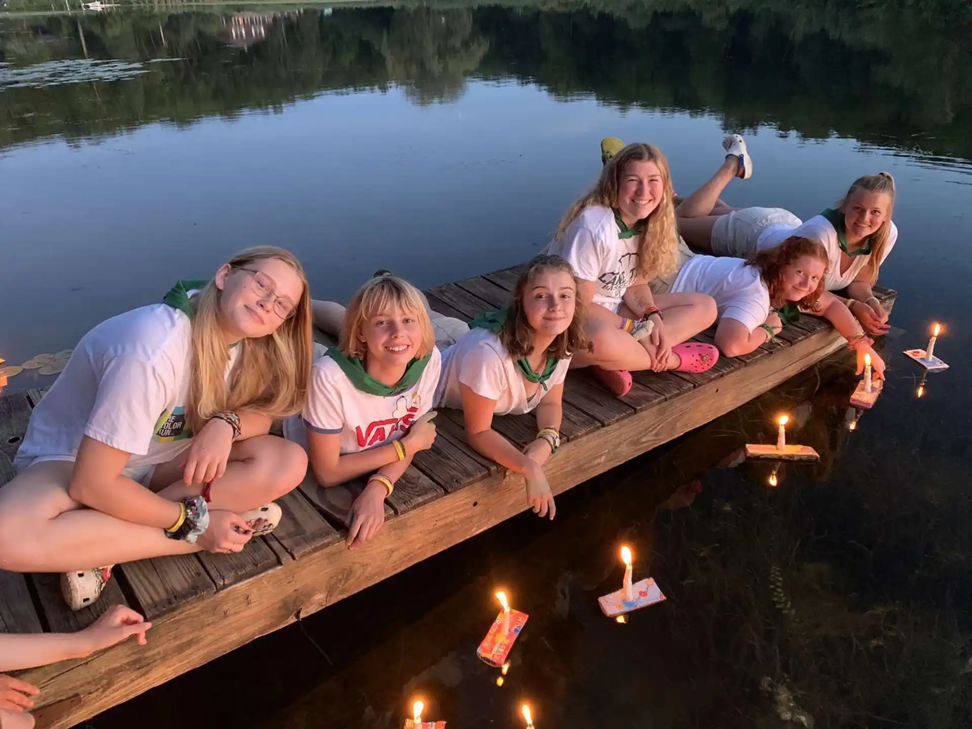 a group of people on a log by a body of water