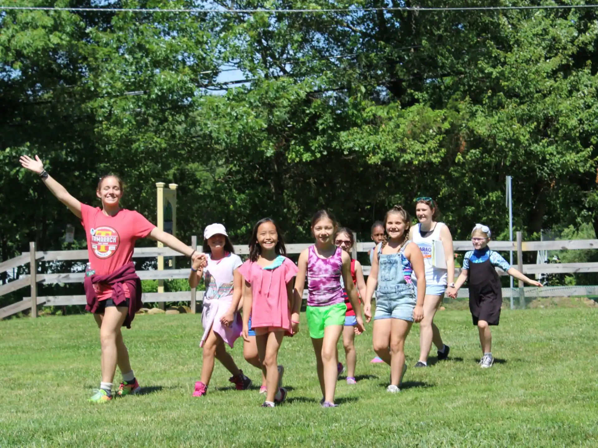 a group of people running on a grass field