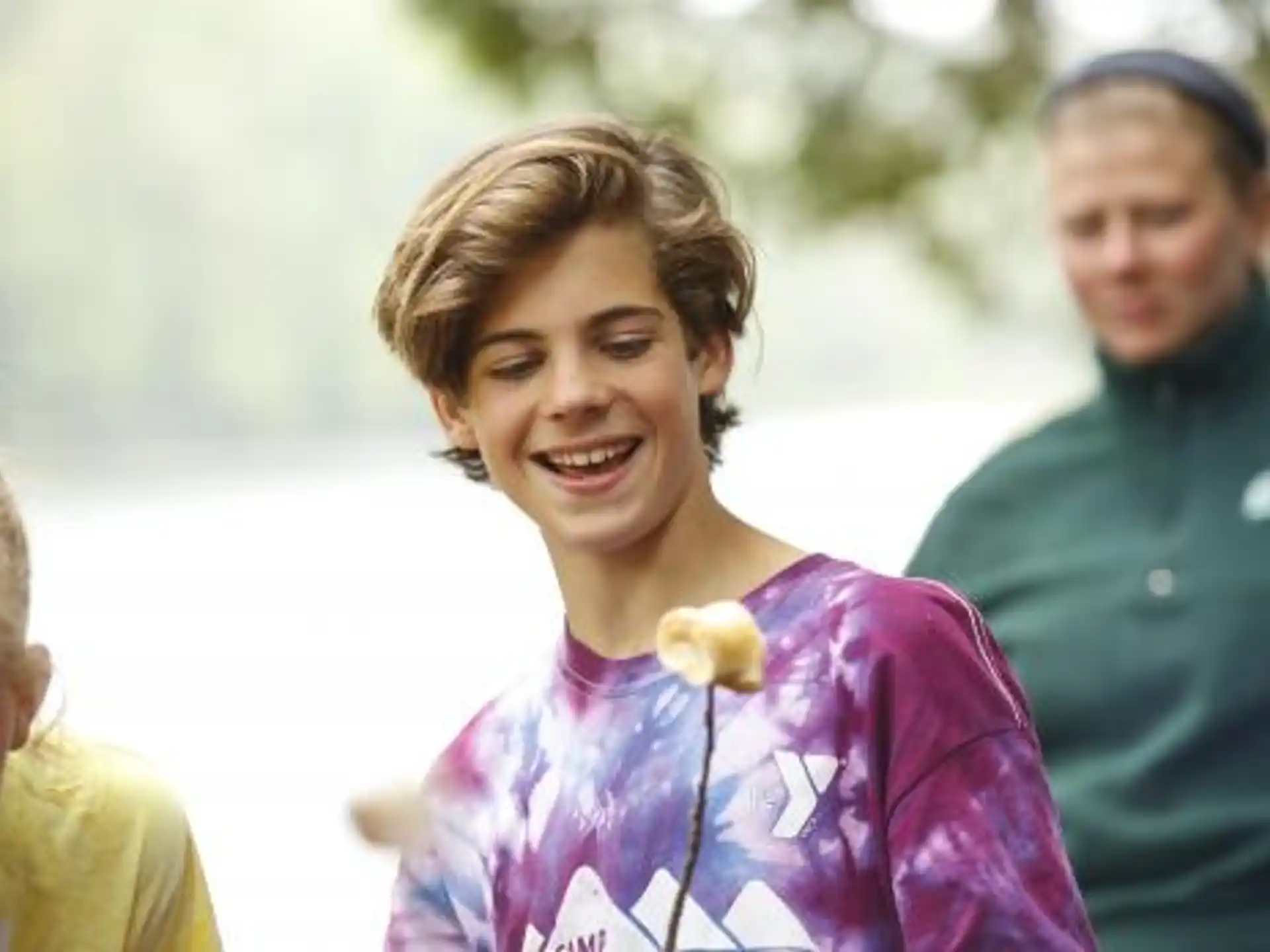 a woman smiling with a man behind her