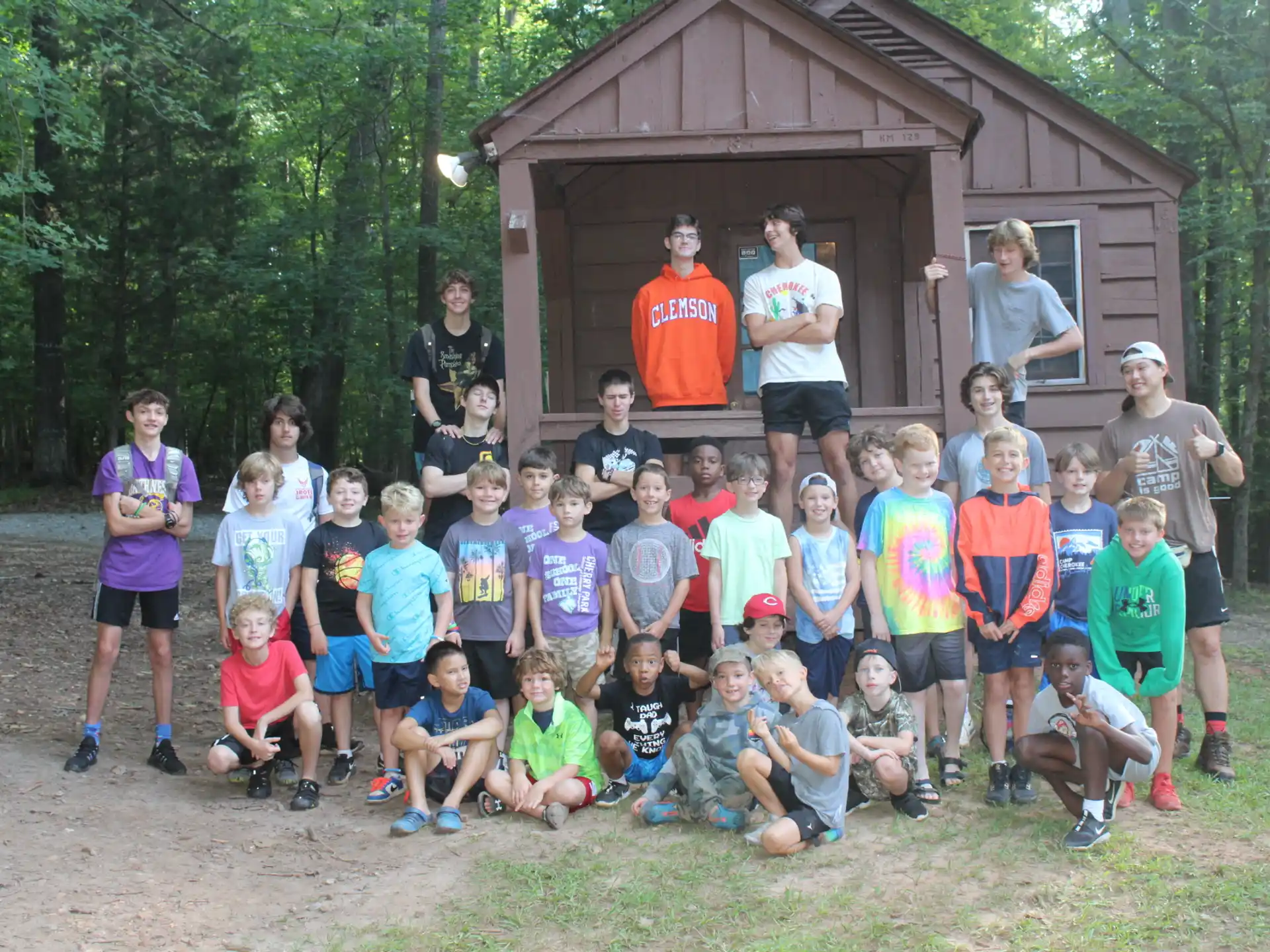 a group of people posing for a photo in front of a log cabin