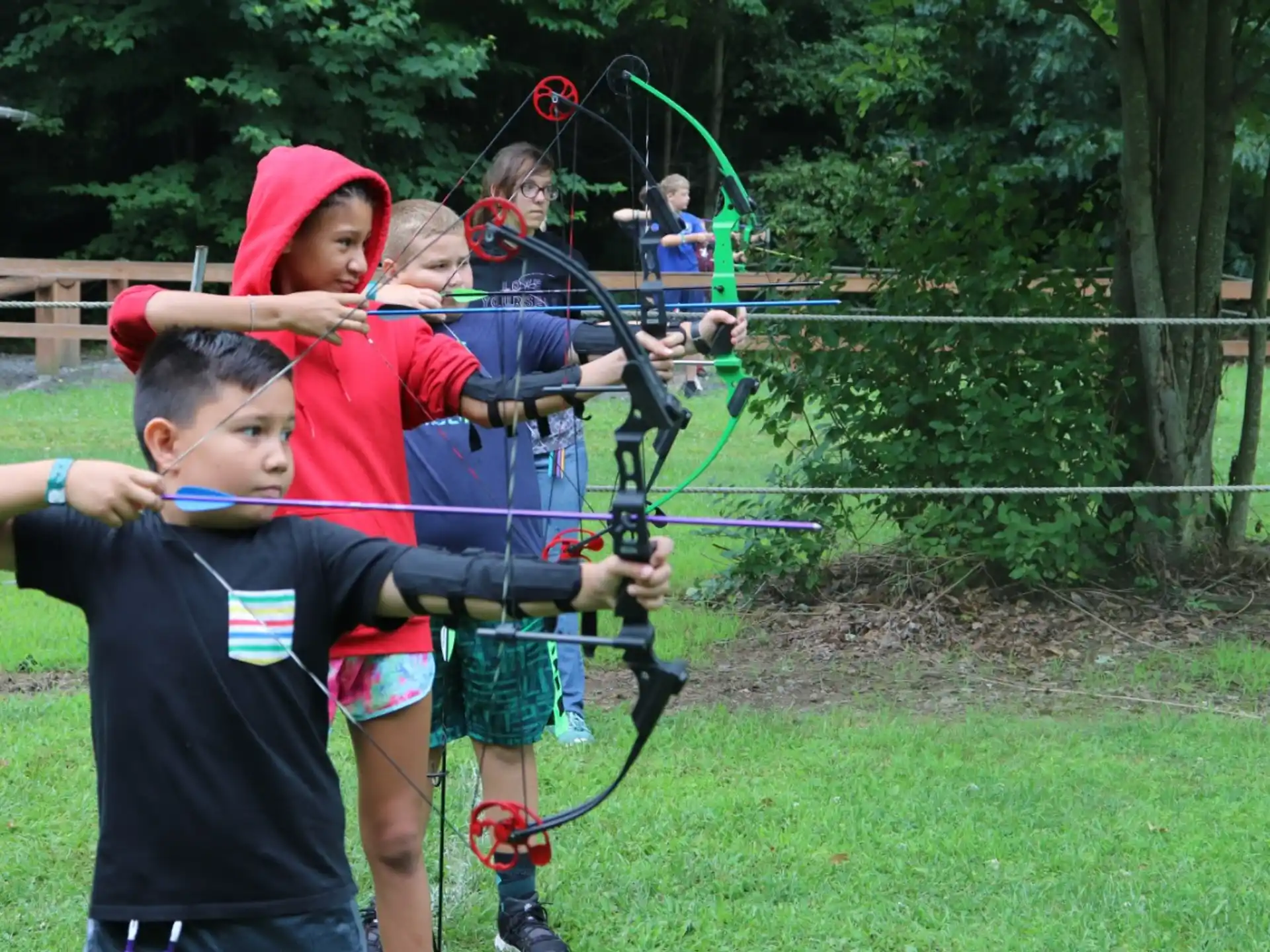 a group of kids playing with bows and arrows