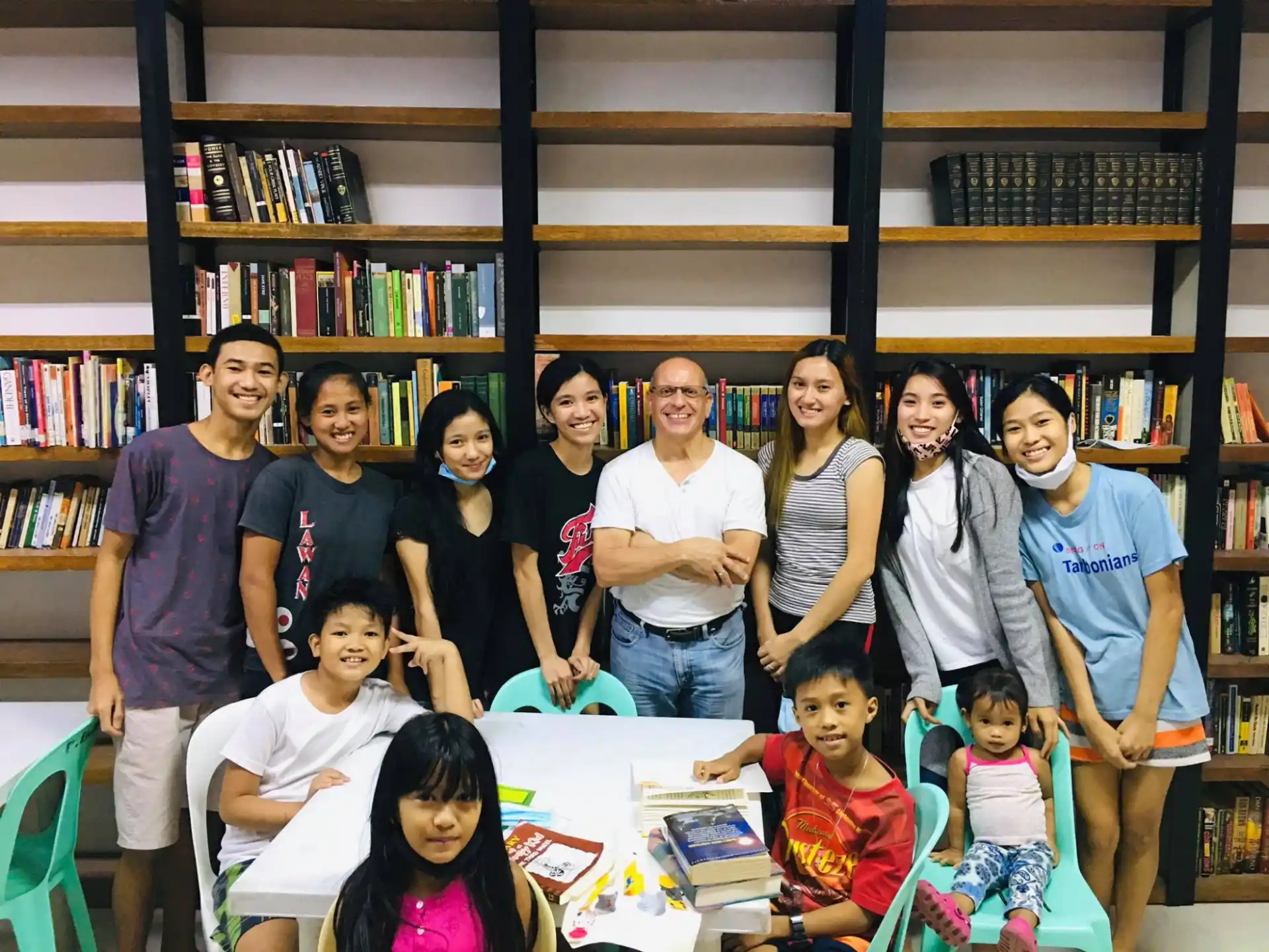 a group of people posing for a photo in front of a bookcase