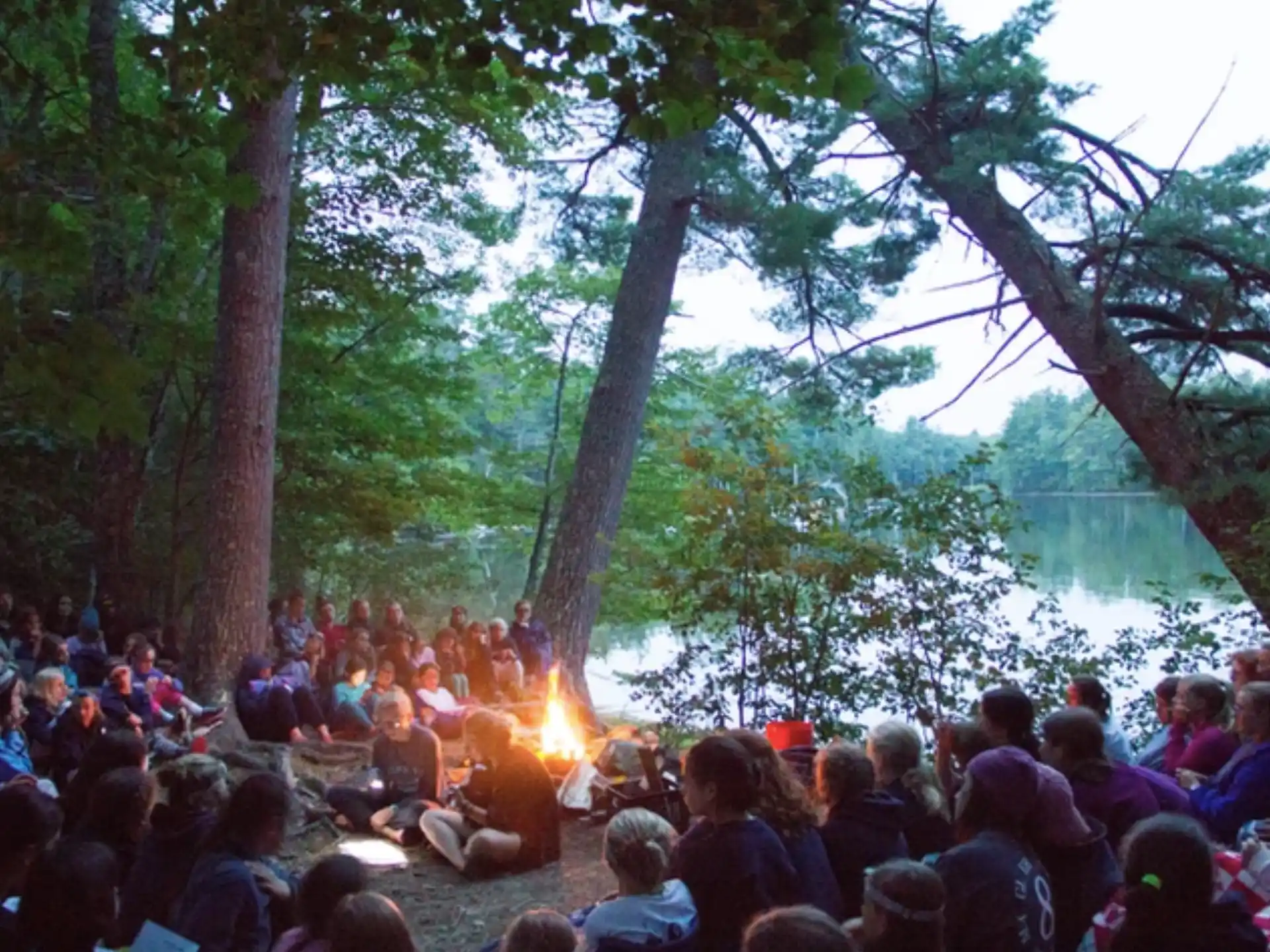 a group of people sitting in a circle under trees