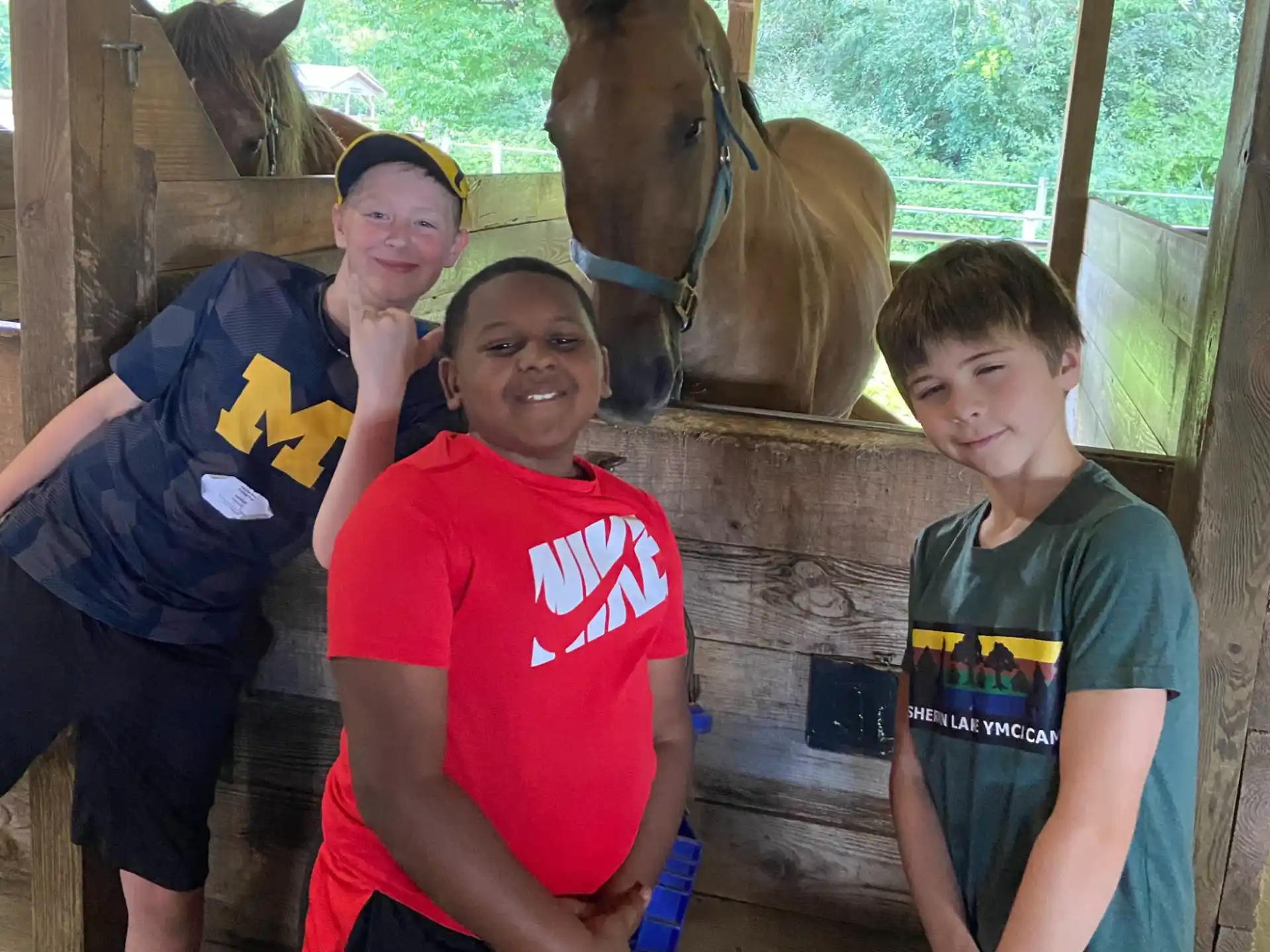 a group of people posing for the camera in front of a horse
