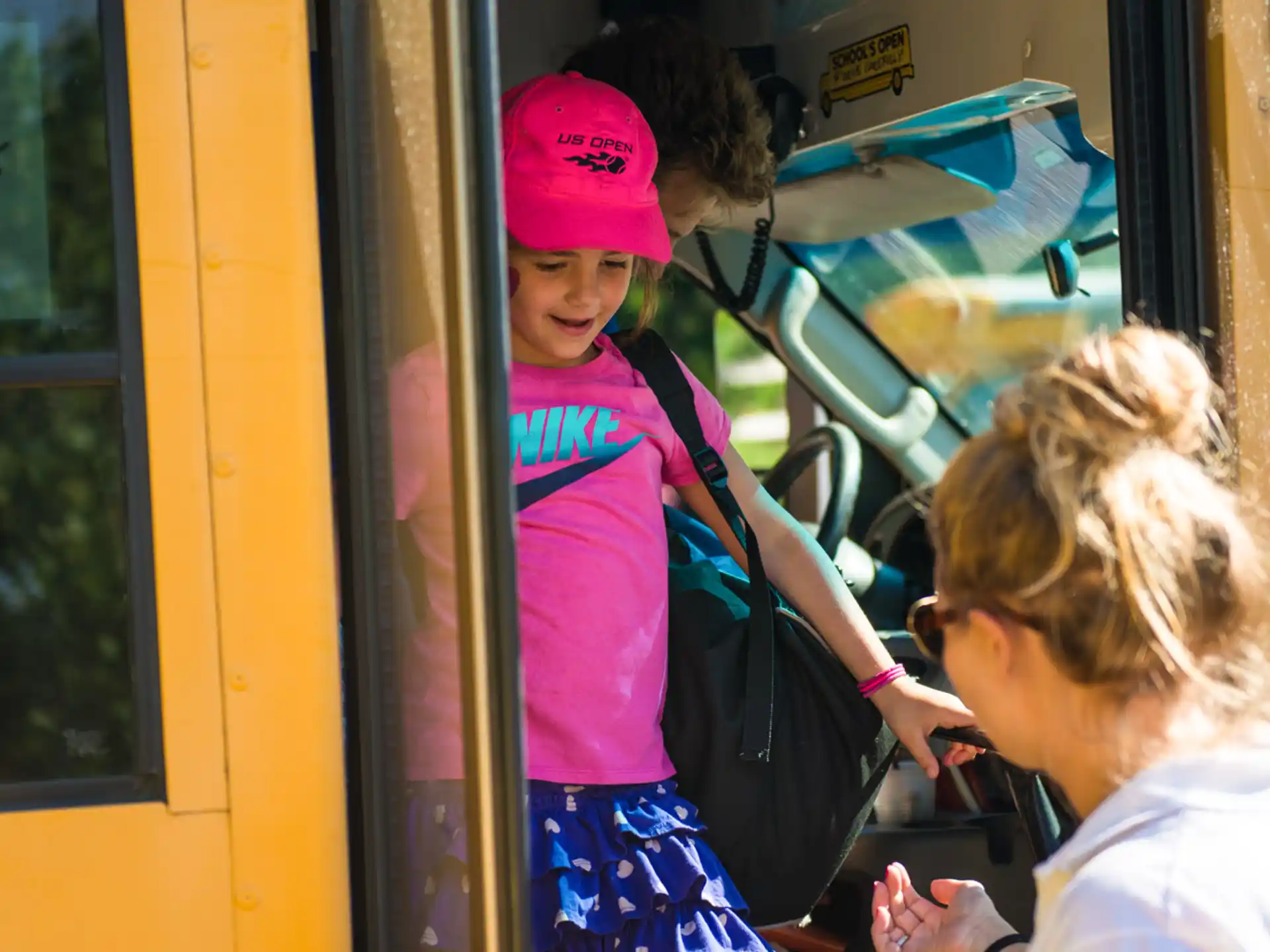 a group of girls stand on a bus