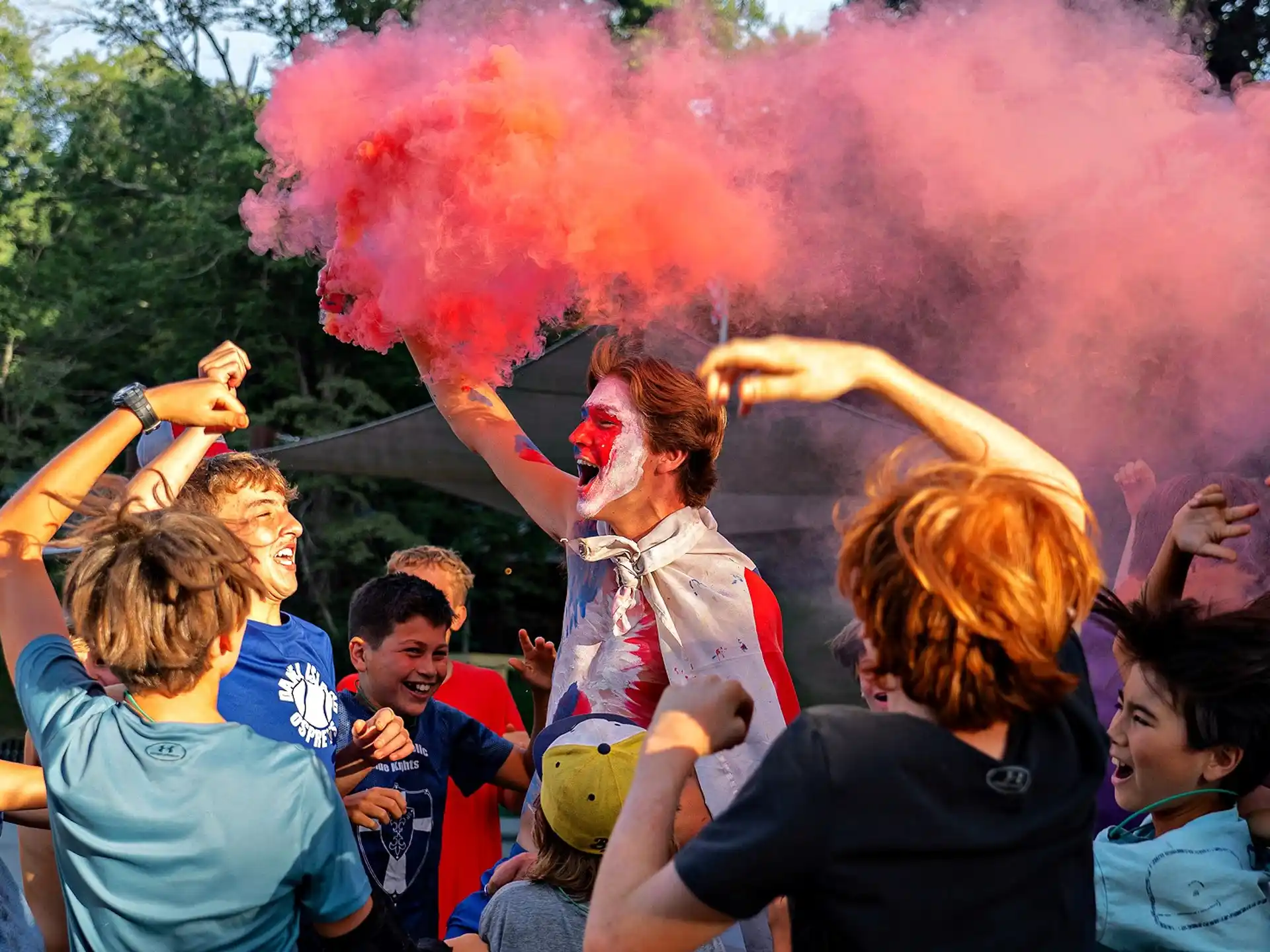 a person with red smoke coming out of the mouth surrounded by people