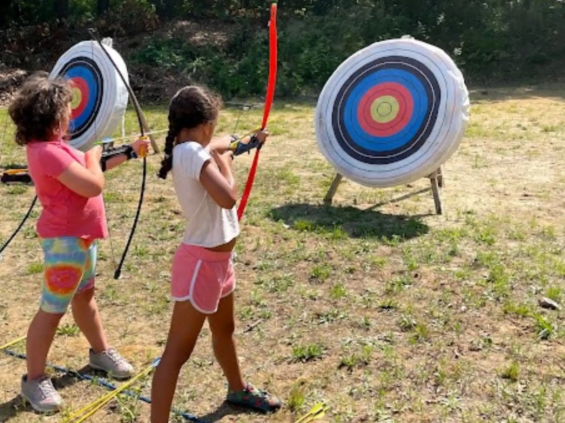 a couple of kids holding bows and arrows
