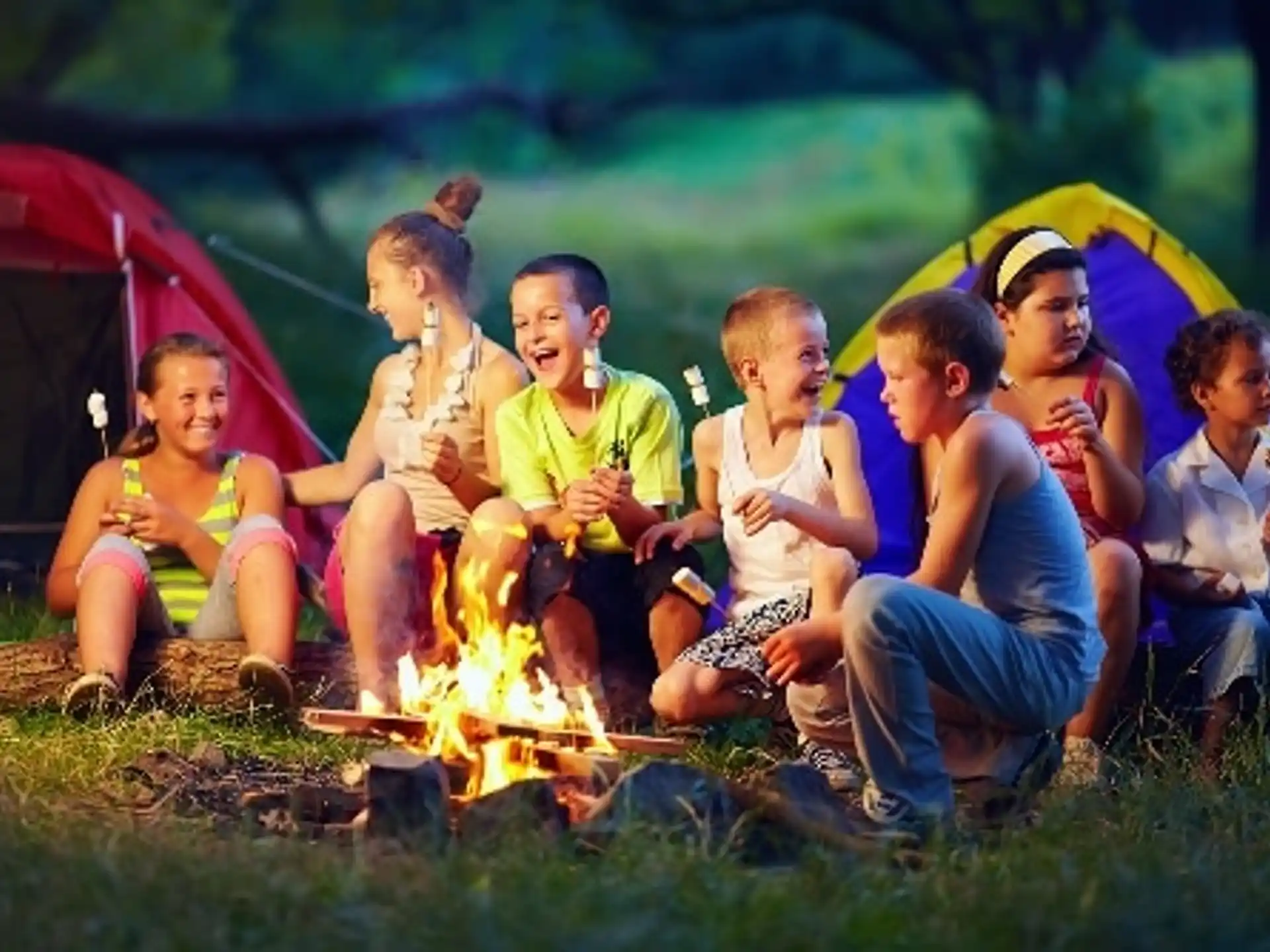 a group of people sitting in a circle in front of a tent