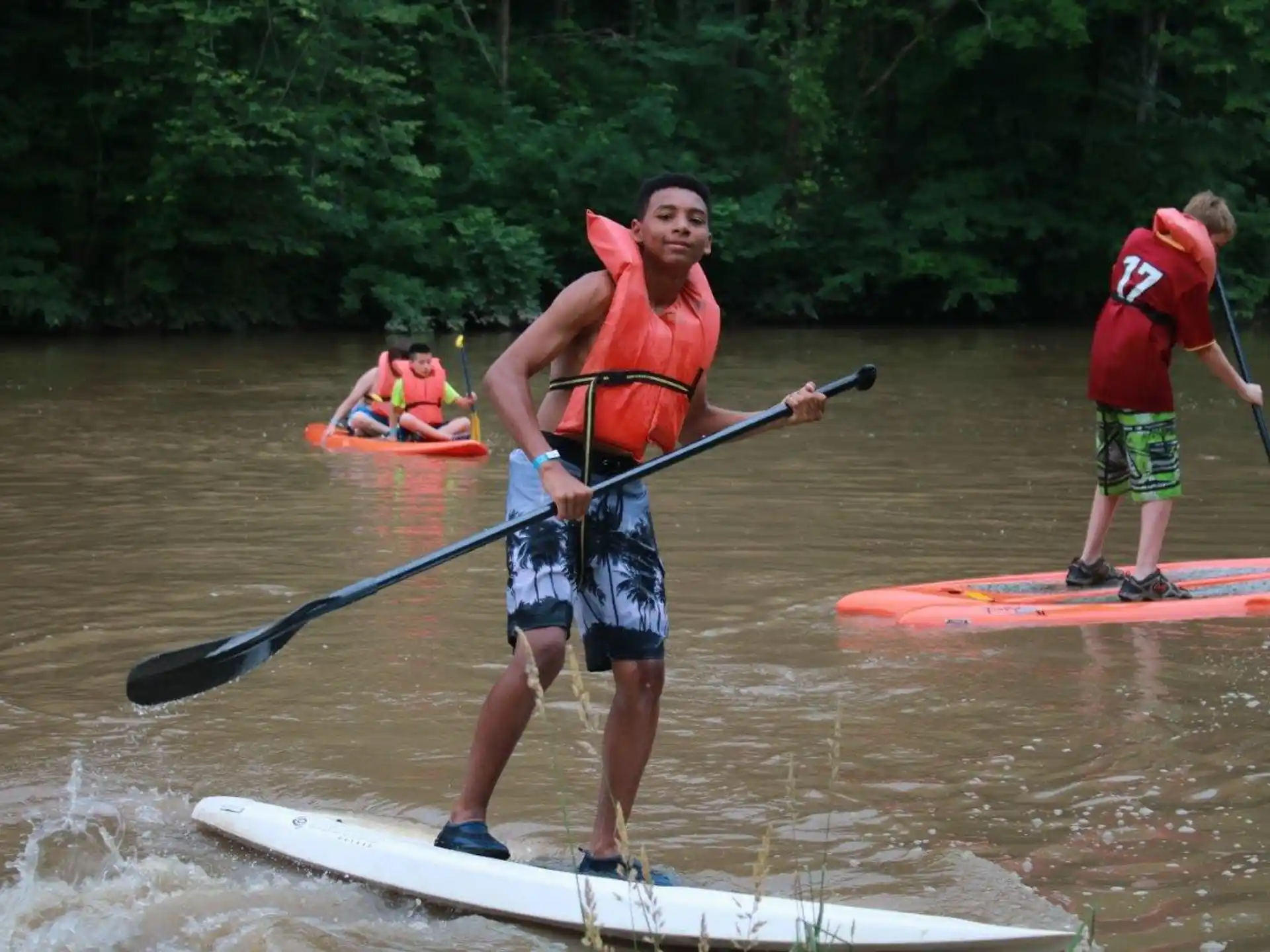a group of people paddle kayaks