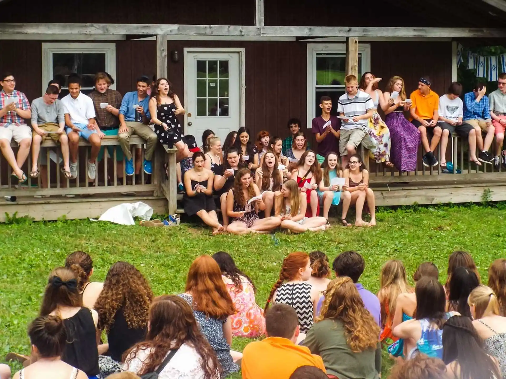 a group of people sitting on a bench in front of a house