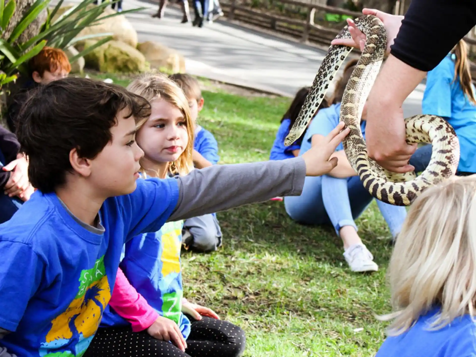 a group of children playing with a snake