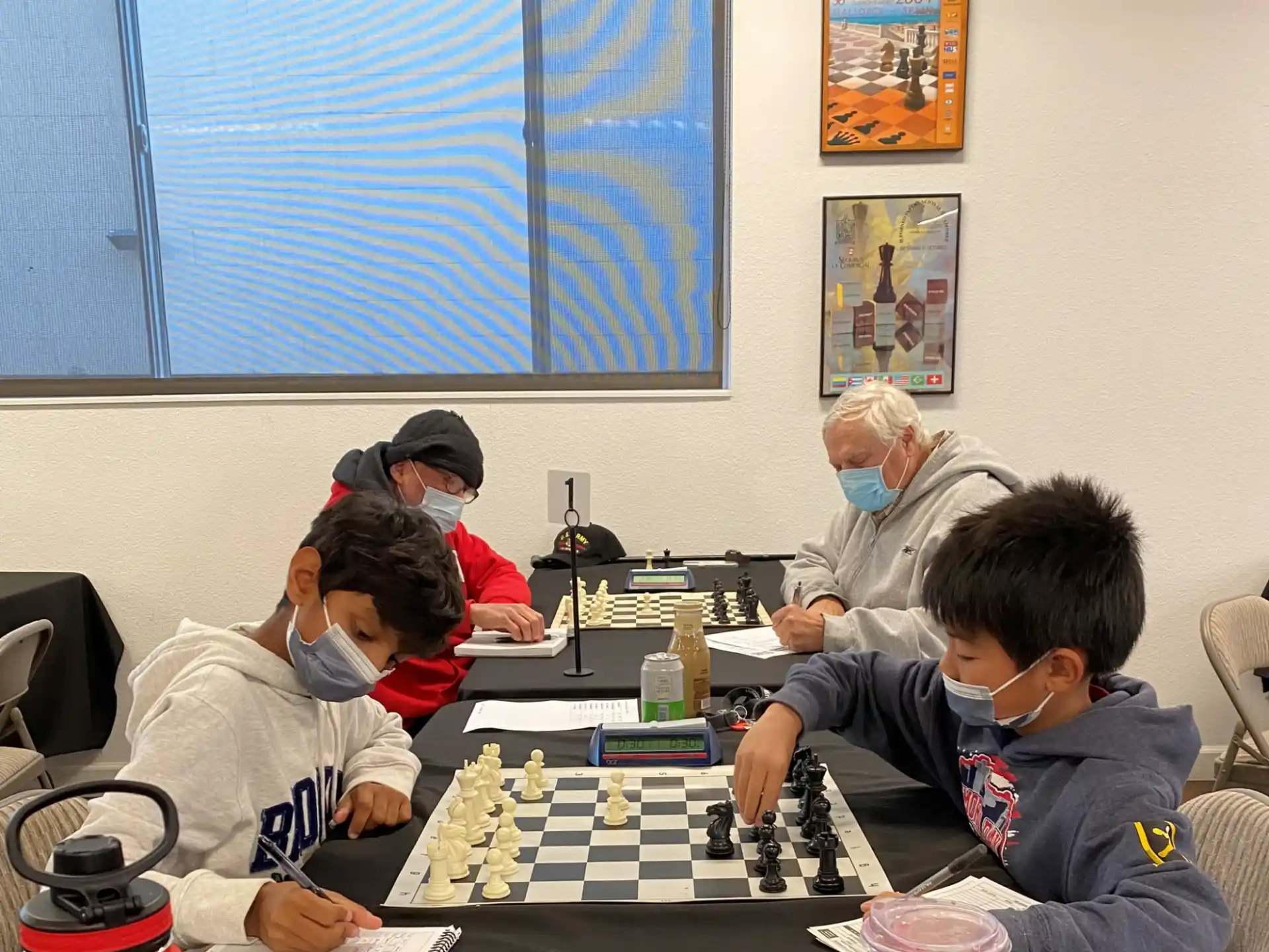 a group of people sitting around a table playing chess