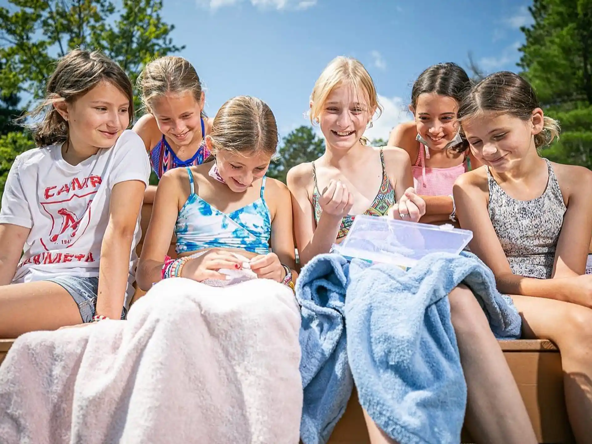 a group of girls sitting on a bench