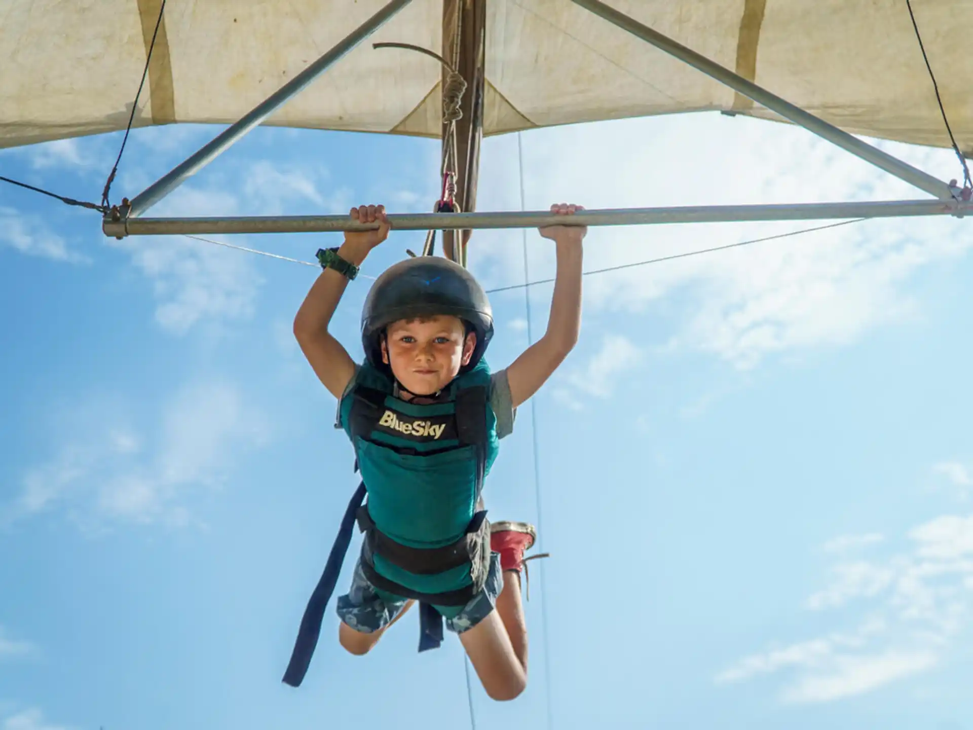 a young girl in a harness on a zip line