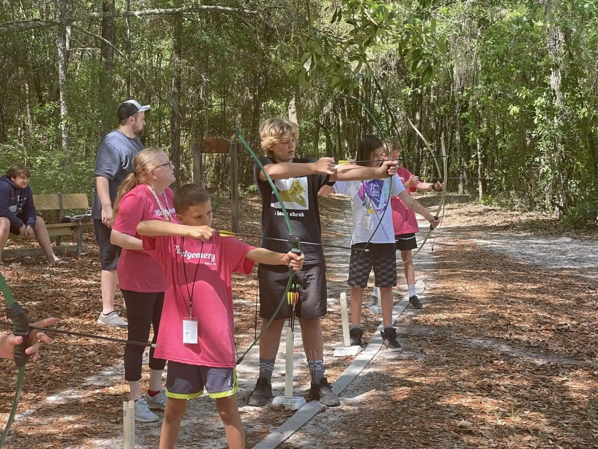 a group of people holding onto a rope in the woods