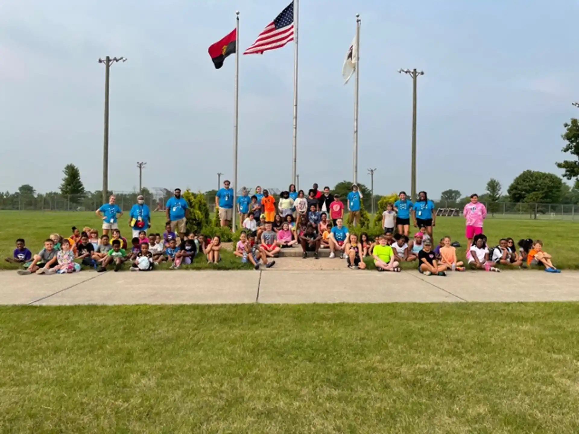 a group of people posing for a photo in front of flags