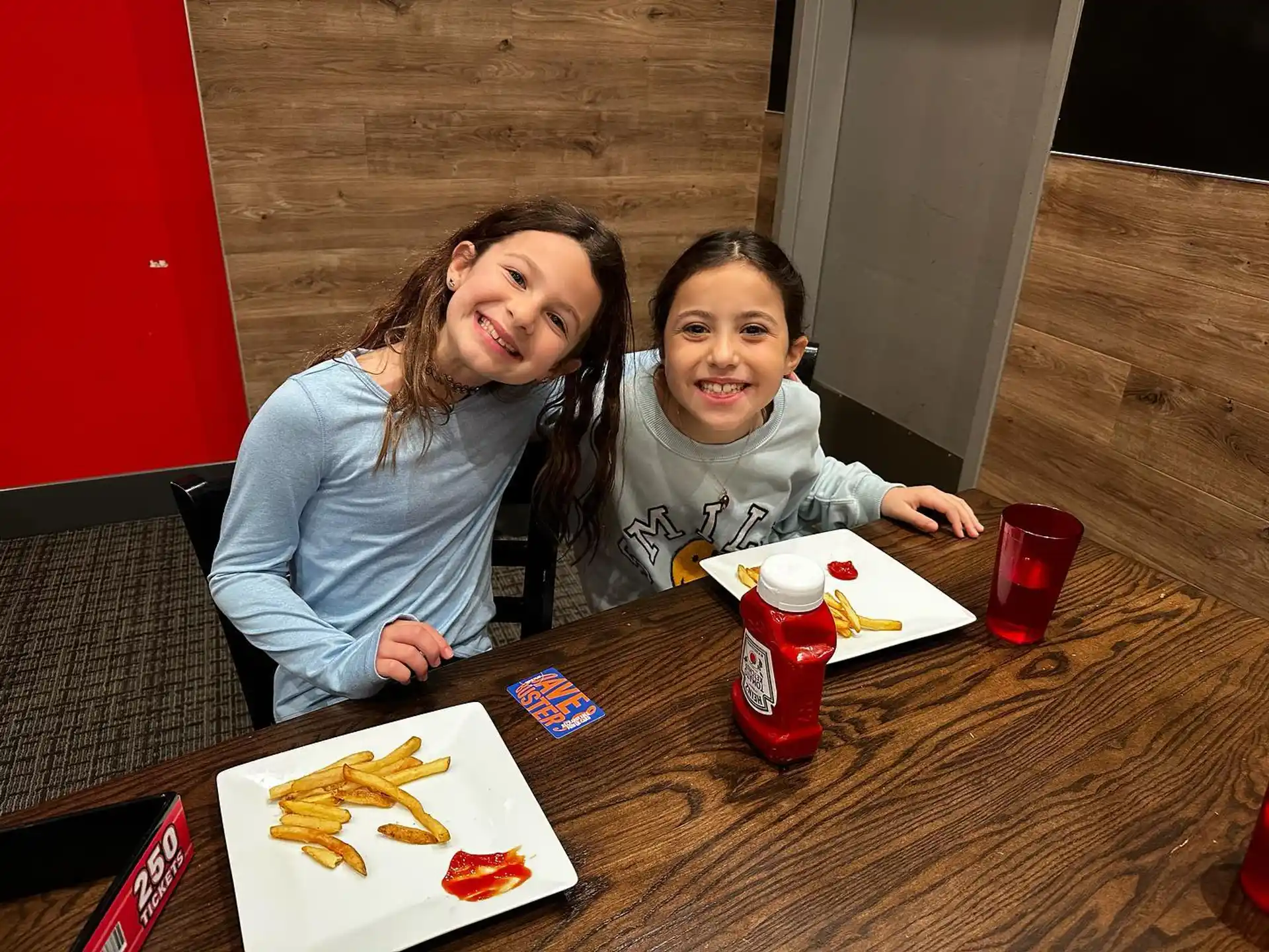 a person and a girl sitting at a table with food