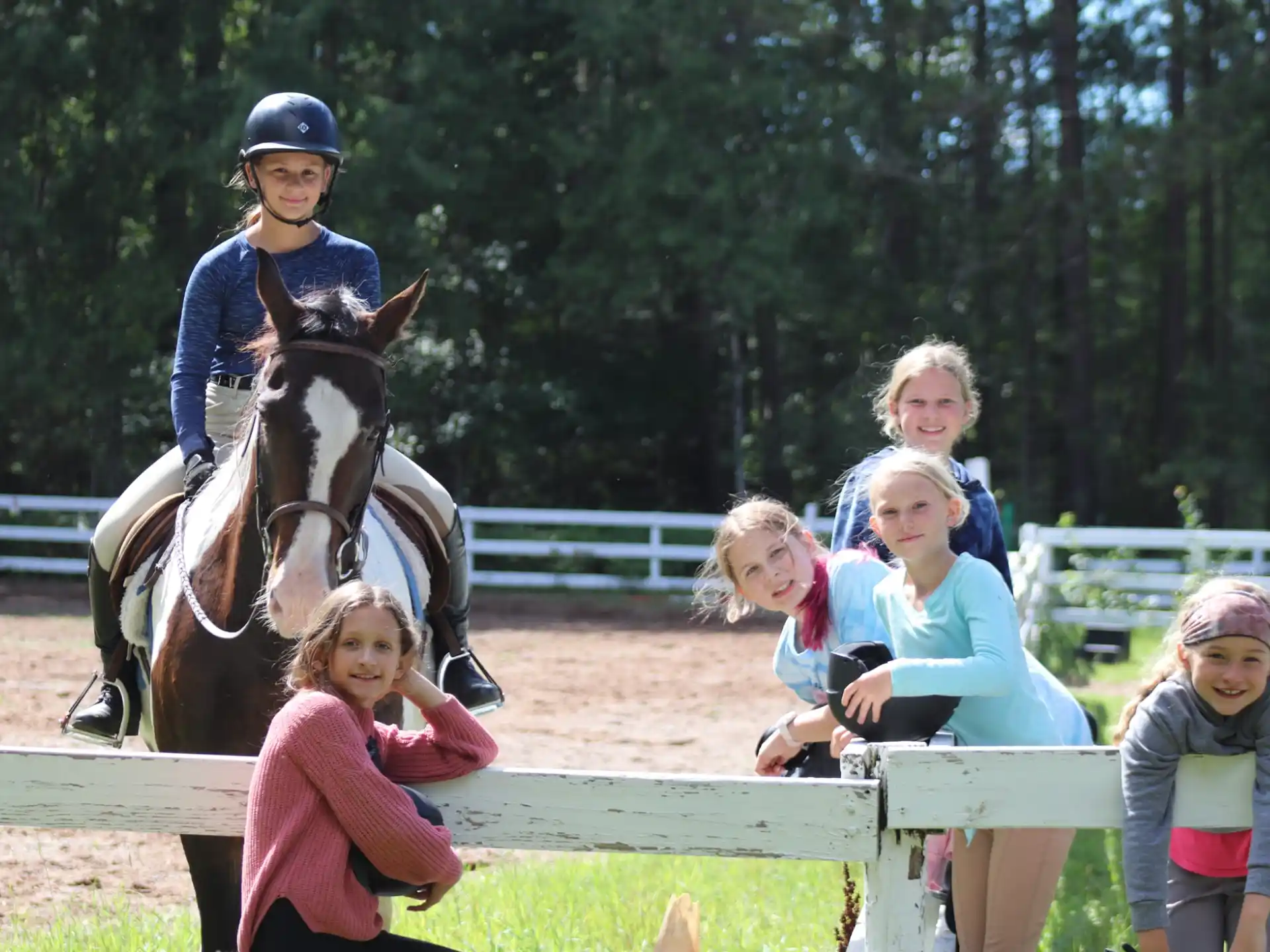 a person riding a horse with a group of children around the