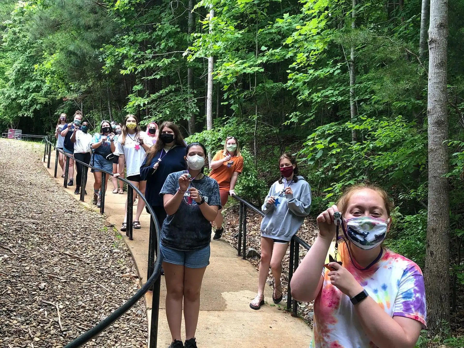 a group of people walking on a trail in the woods