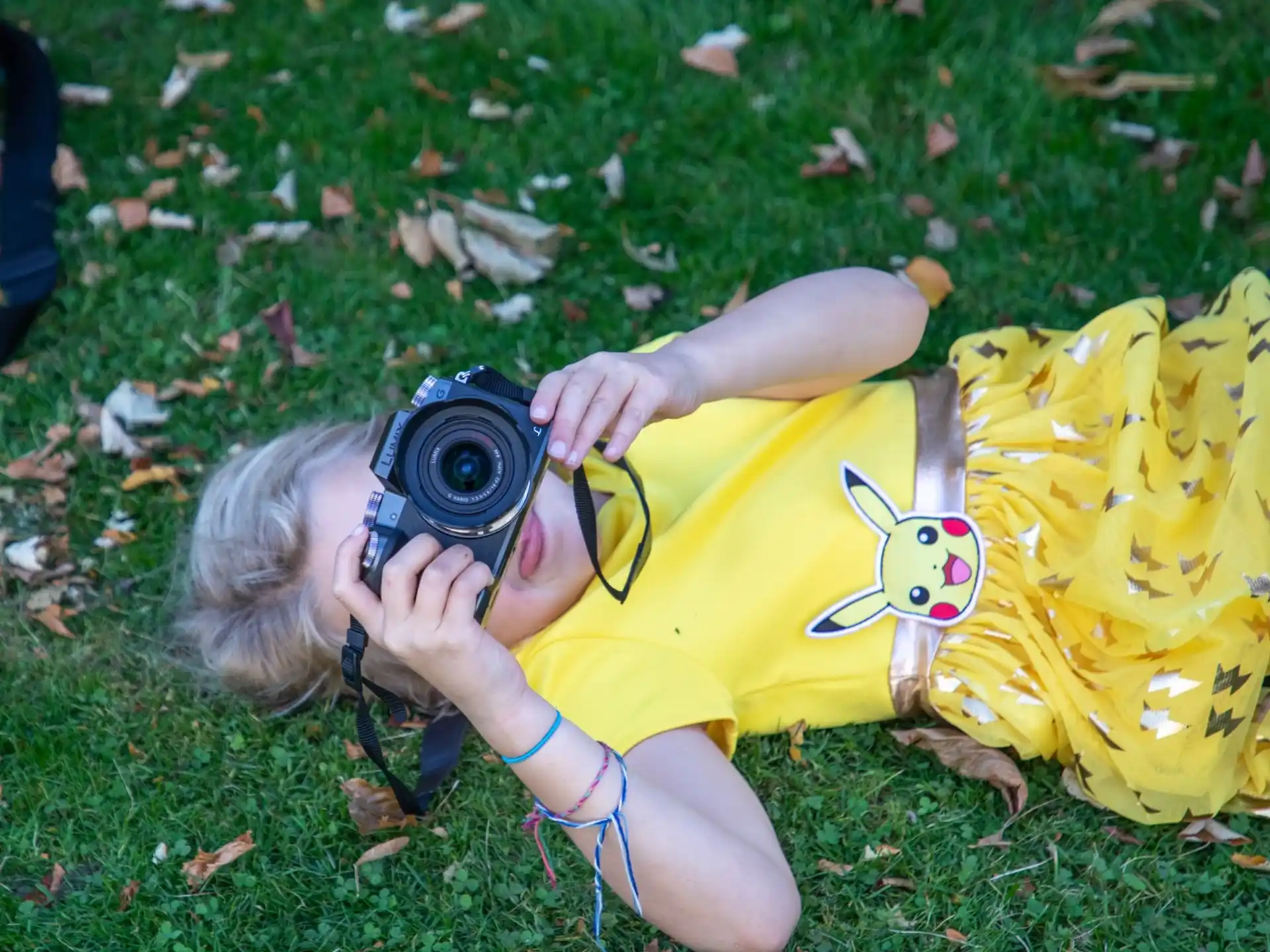 a person lying on the grass with a camera