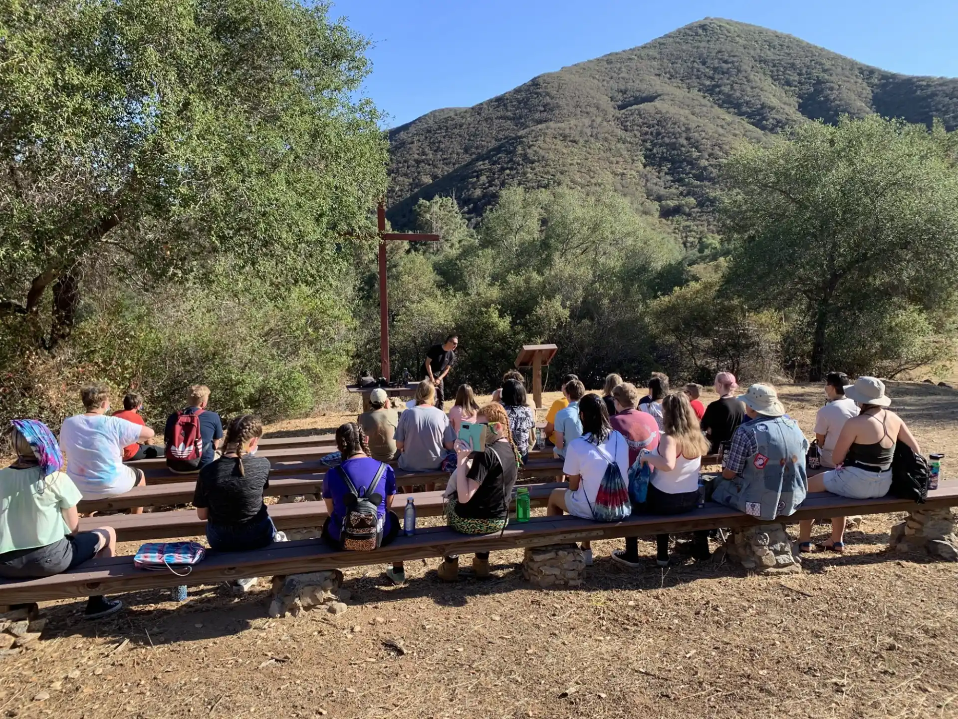 a group of people sitting on a bench in front of a bridge