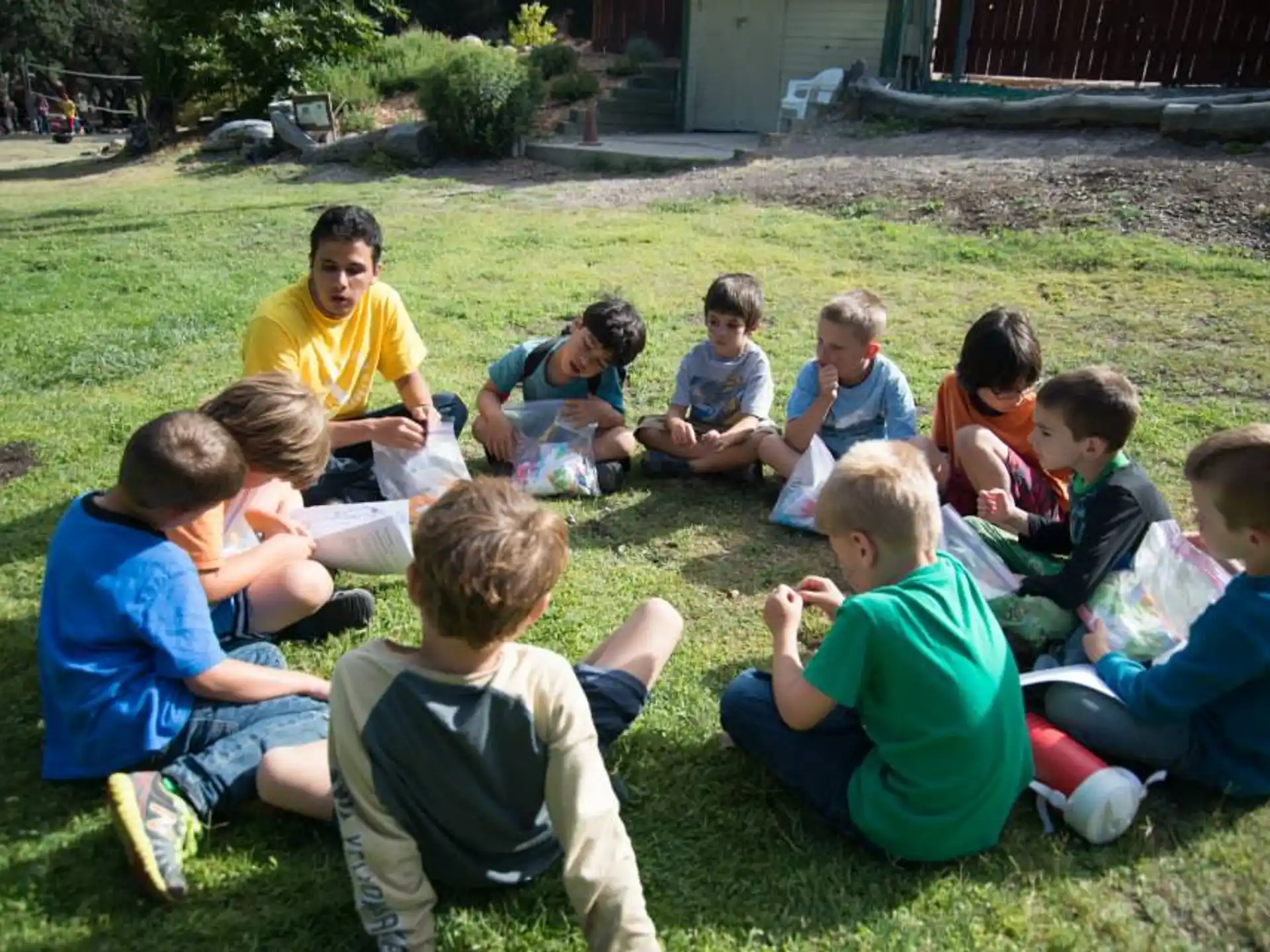 a group of children sitting on the grass