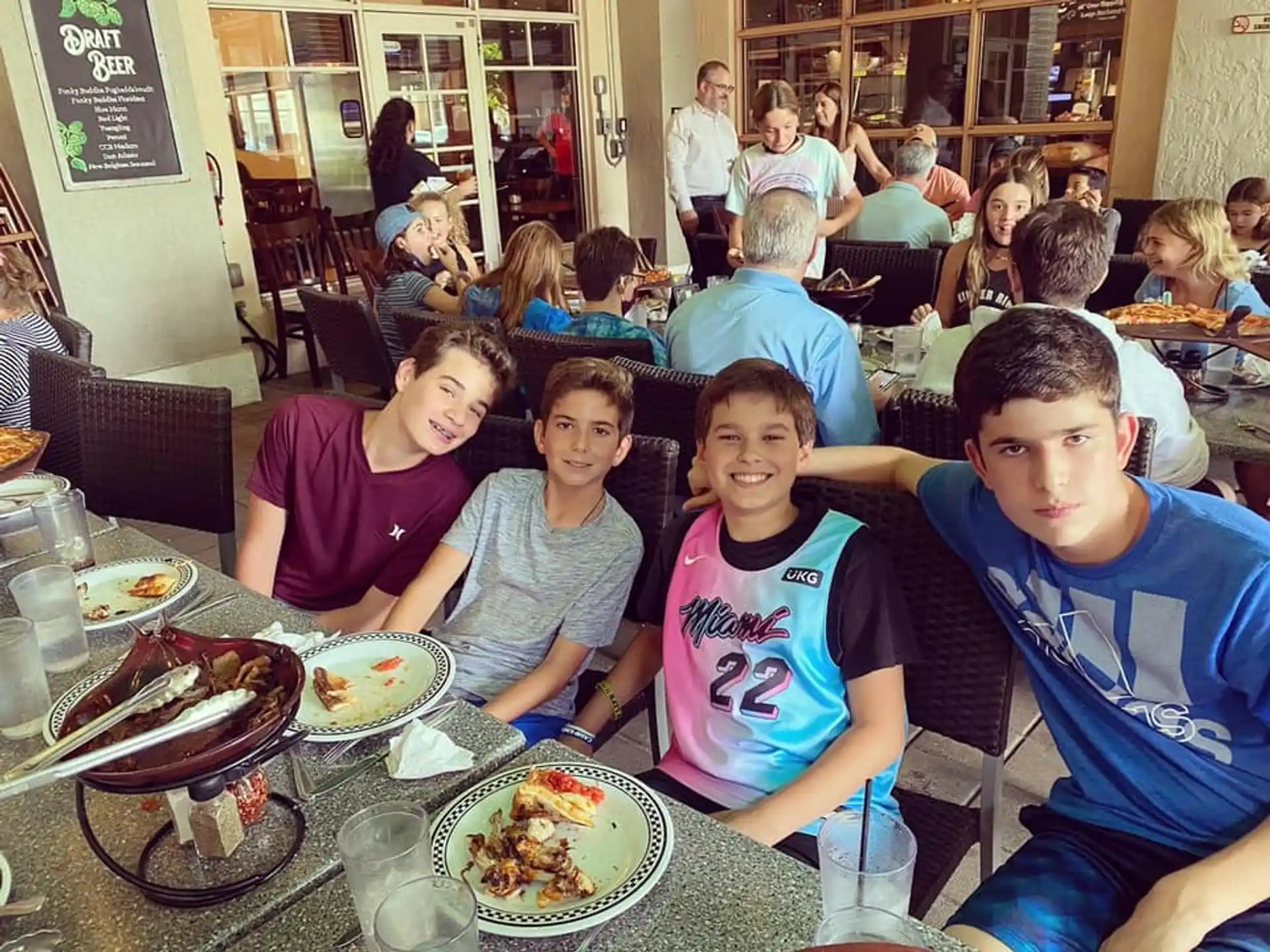 a group of people sitting at a table with food
