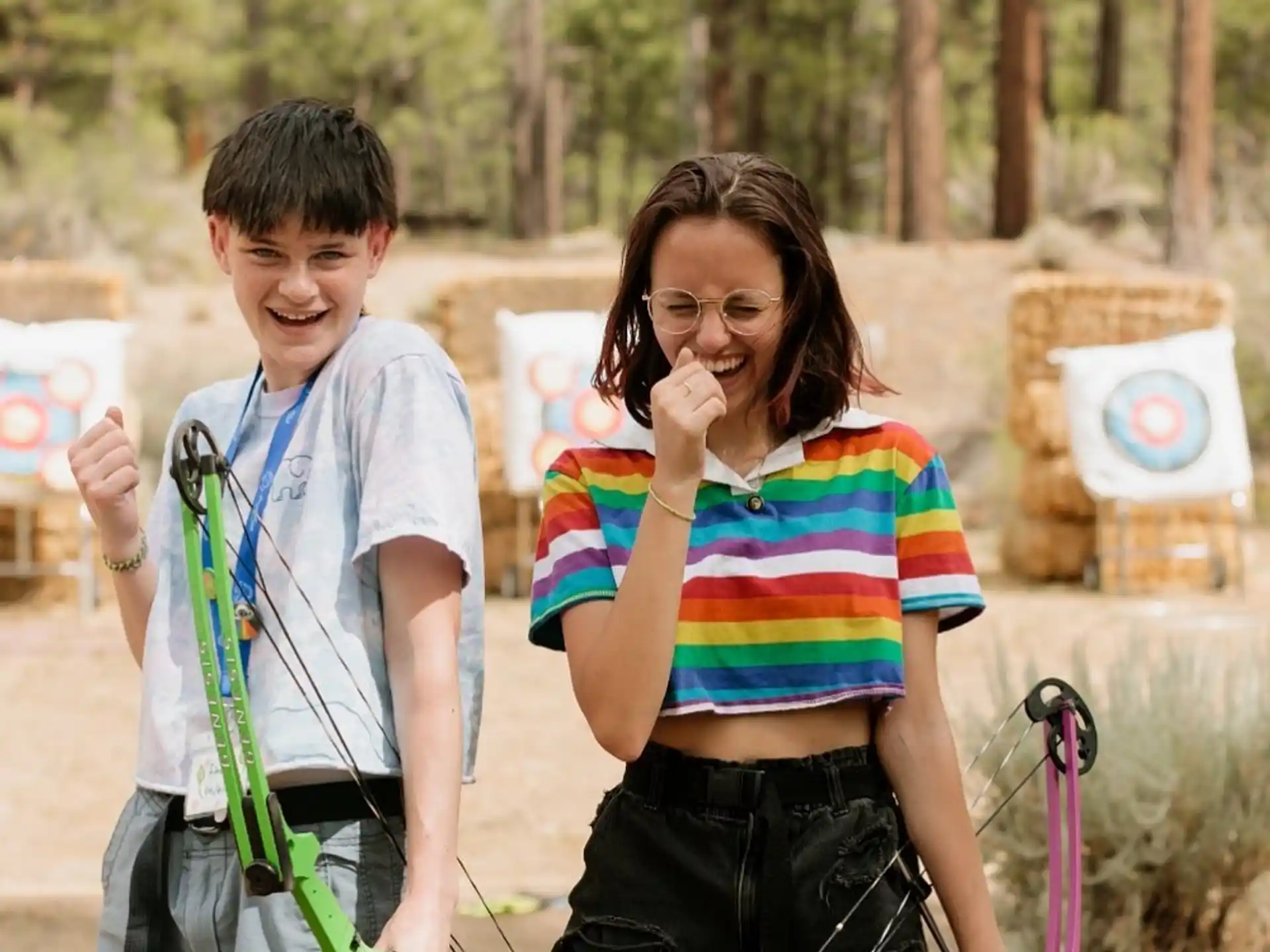 a person and a boy standing in a wooded area