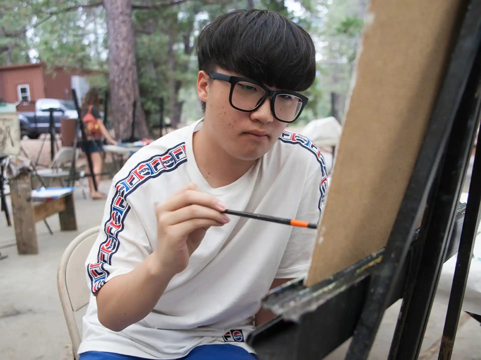 a person sitting in a chair and holding a pencil