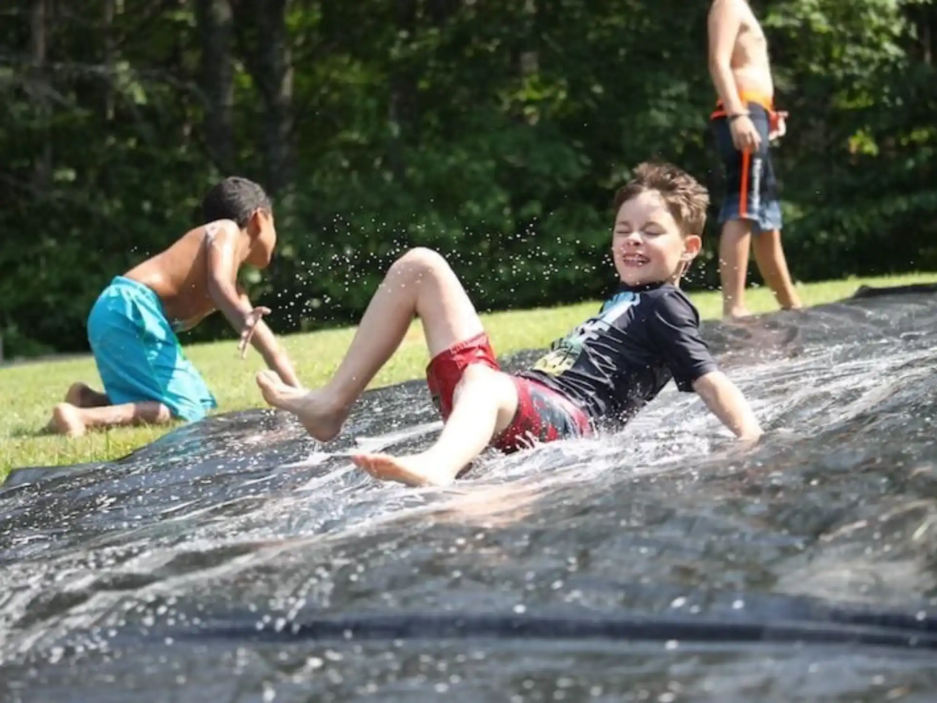 a group of boys playing in a water fountain
