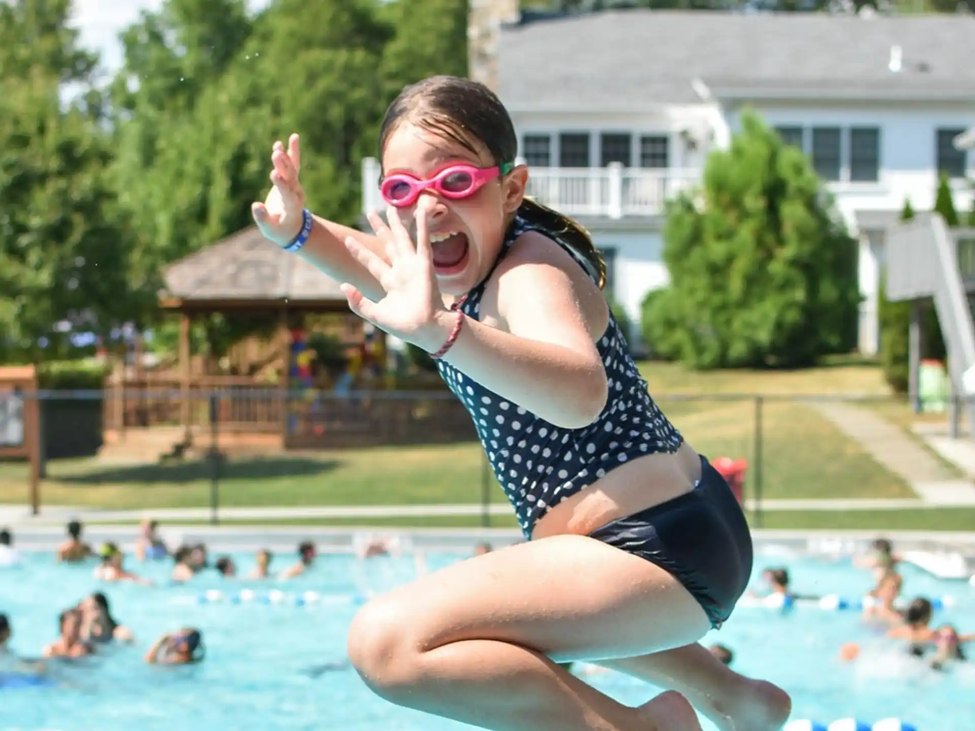 a person in a swimsuit jumping into a pool