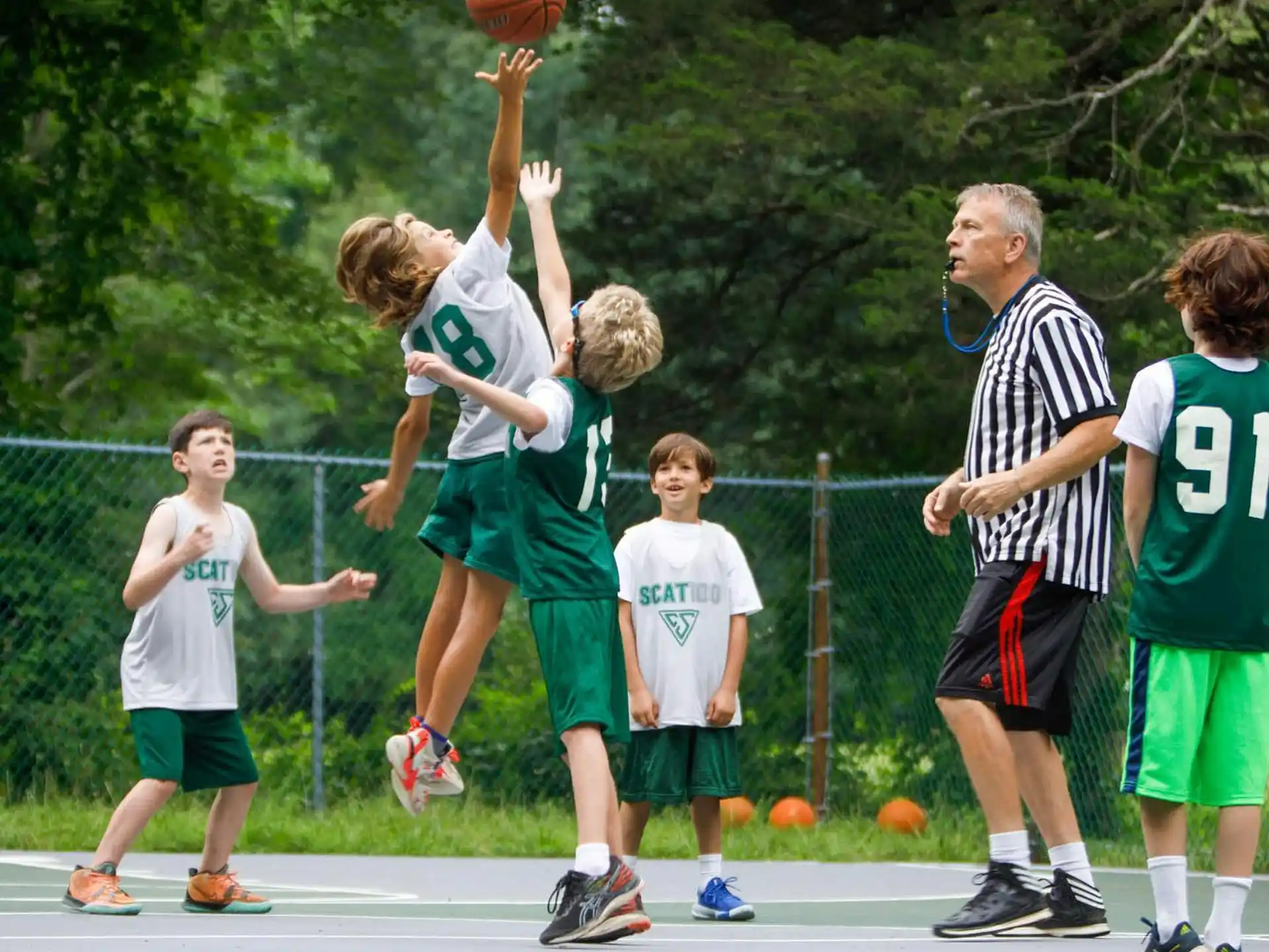 a group of kids playing basketball