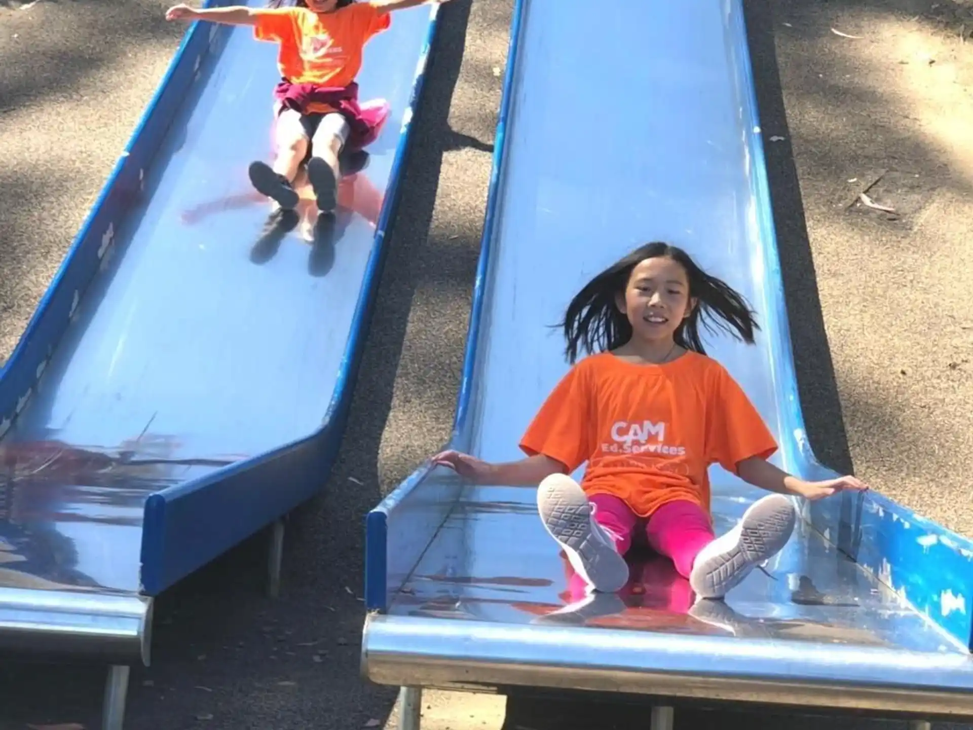 a couple of kids playing on a slide