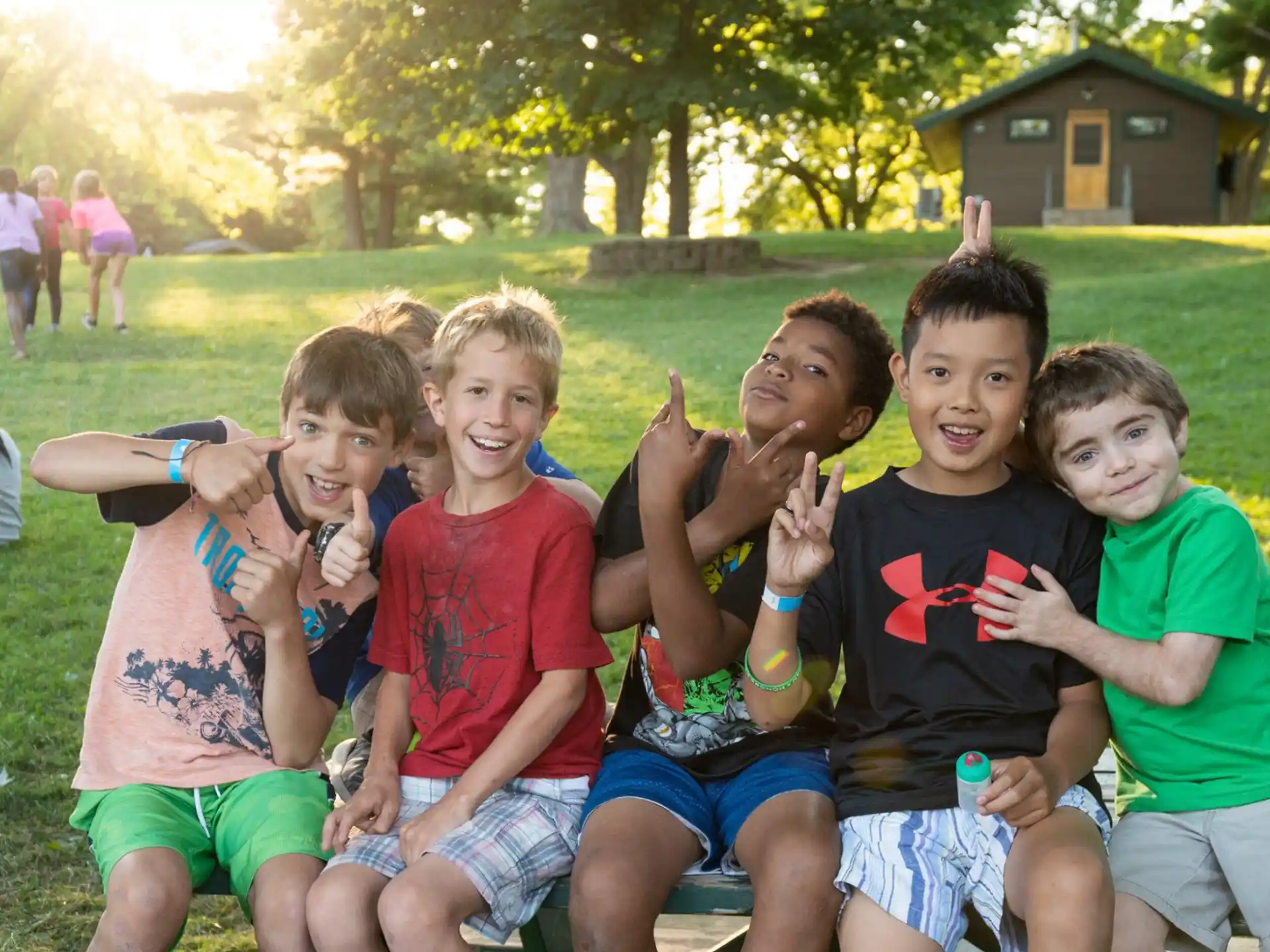 a group of boys sitting on a bench in a park