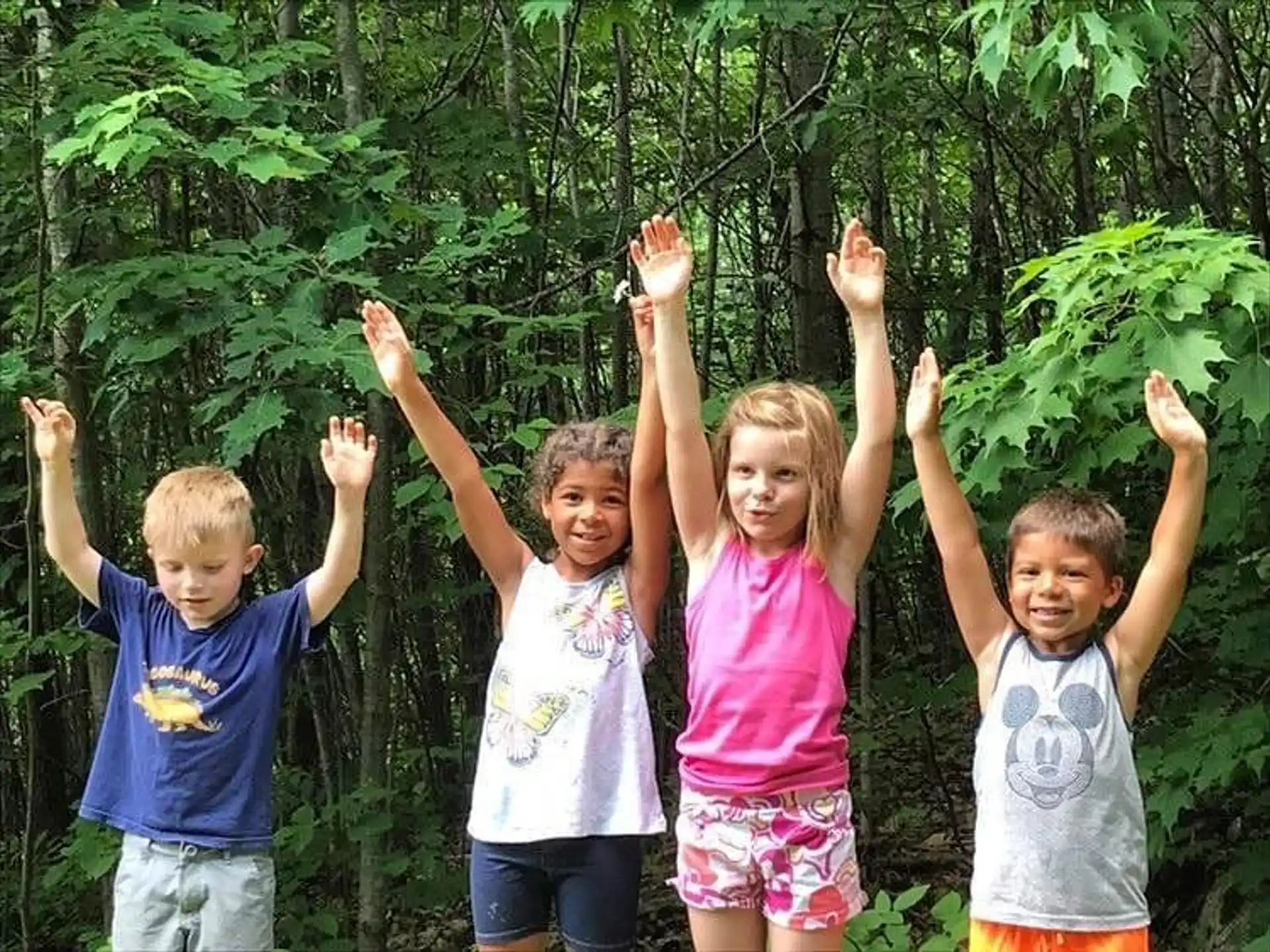 a group of children holding their hands up in the air