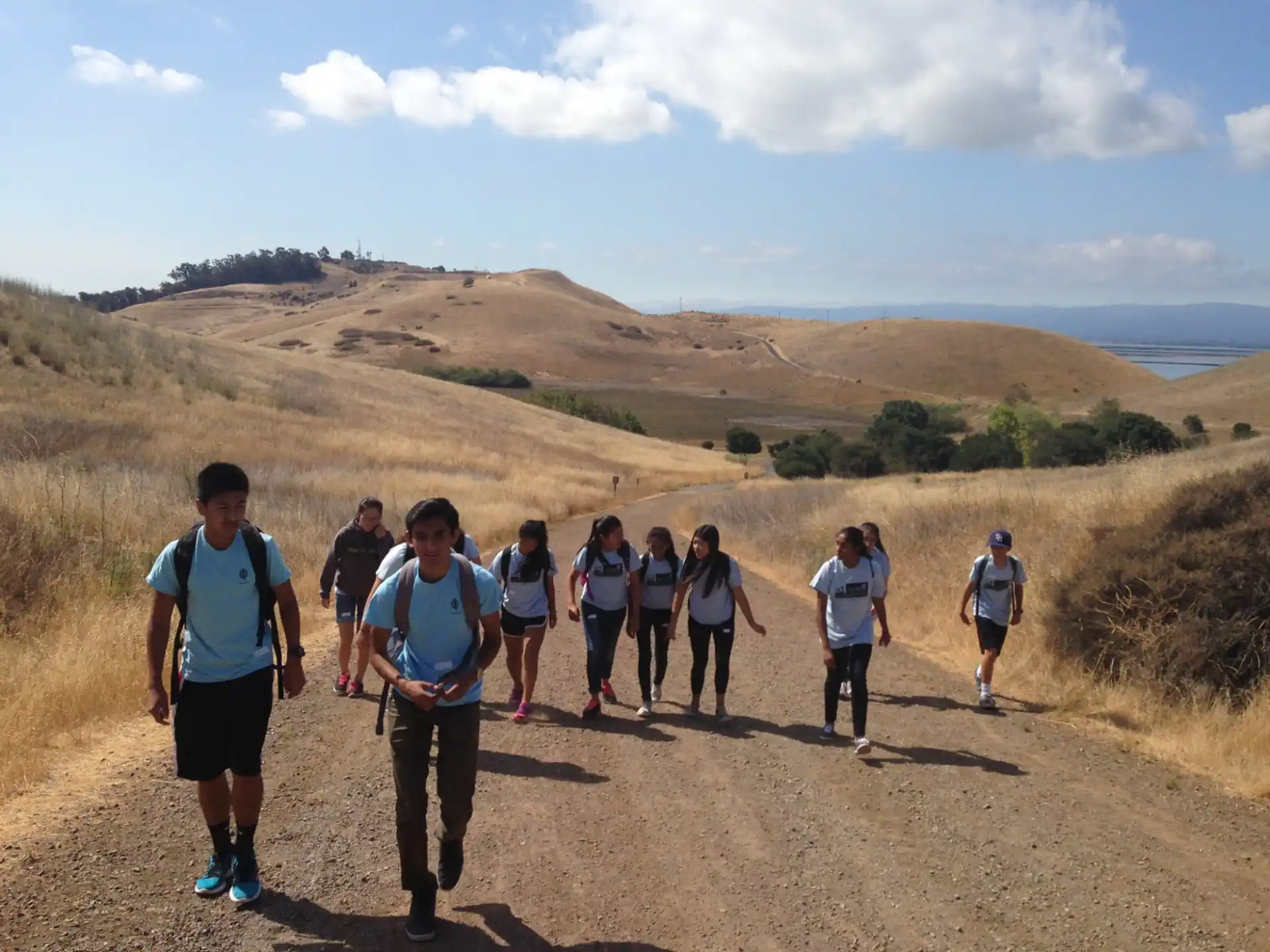 a group of people walking on a dirt road