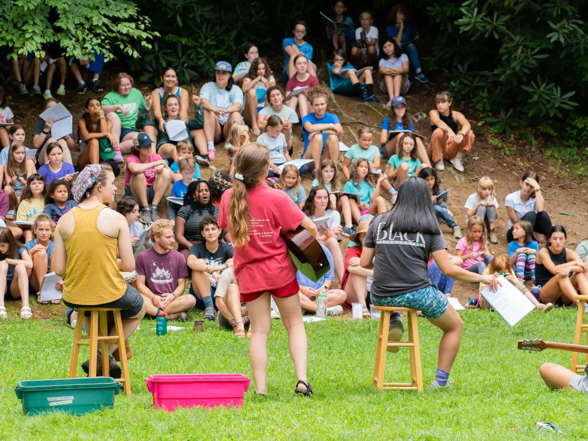 a group of people sitting on stools in front of a crowd