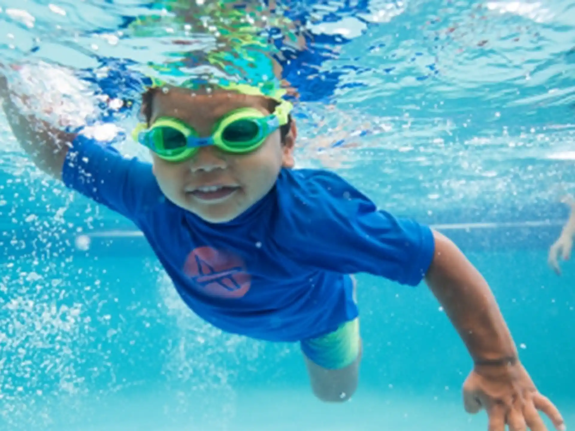 a boy wearing goggles and swimming